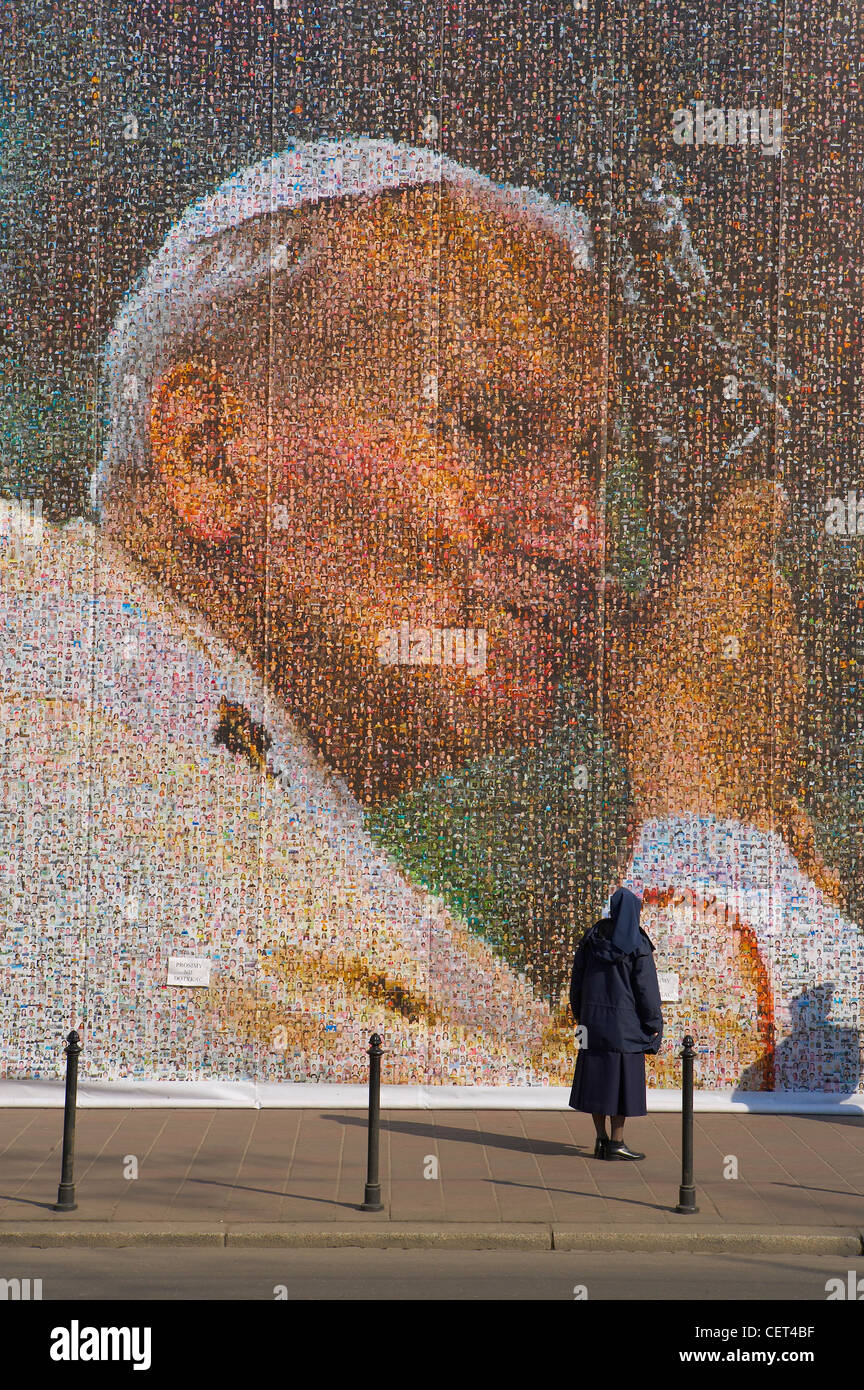Une religieuse à un énorme collage du Pape Jean Paul II, Krakow (Cracovie, Pologne) Banque D'Images