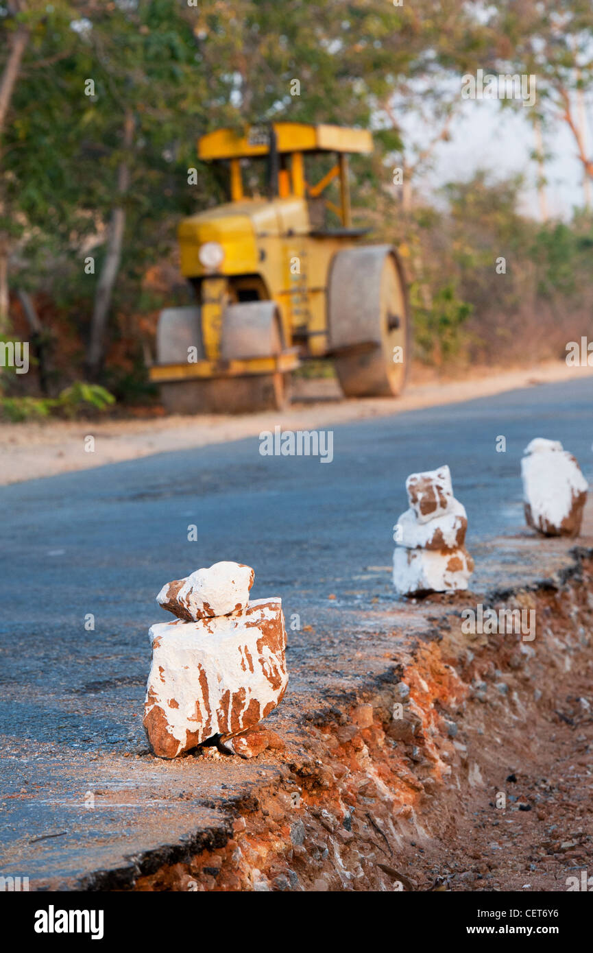 La construction de routes rurales indiennes avec rouleau compresseur à l'arrière-plan. L'Andhra Pradesh, Inde Banque D'Images