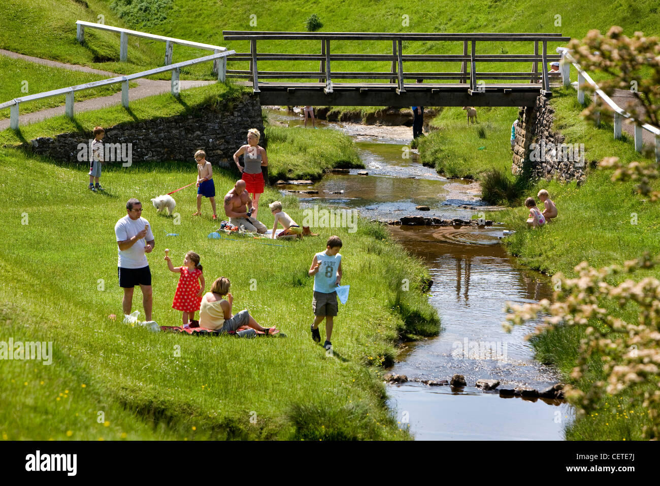 Les familles se détendre par le flux à Hutton Le Hole, pittoresque village de la lande du Yorkshire, England, UK. Banque D'Images