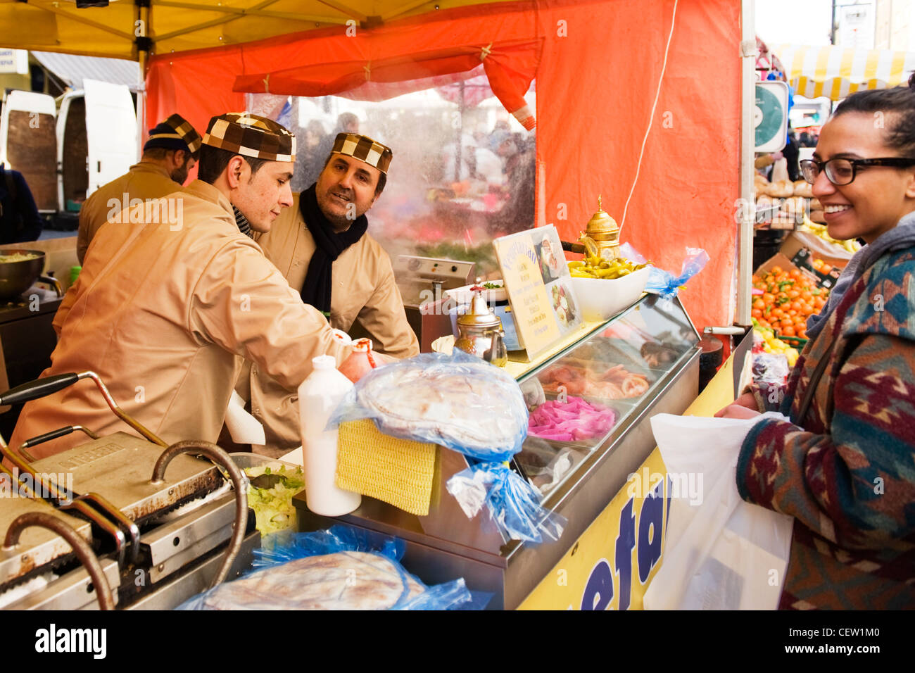 La rue Portobello Road Market Londres végétarienne marocaine fast food falafel enveloppements enveloppement jeune homme servant jolie fille Banque D'Images