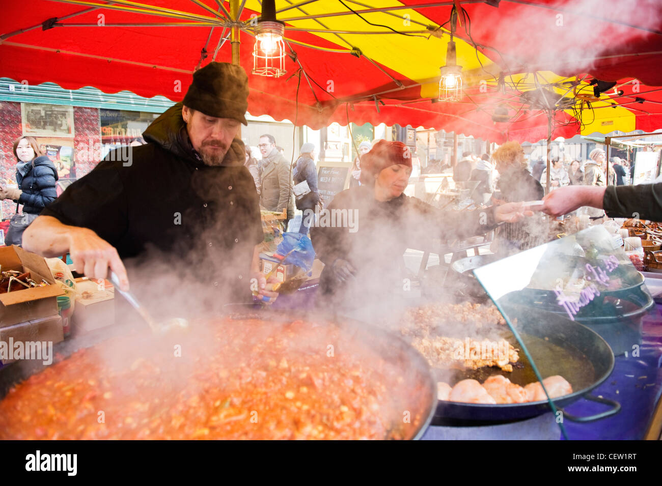 Portobello Road Market Street , LONDRES , Restauration rapide , grande casserole de poulet piri piri remué par barbu entouré par la vapeur Banque D'Images