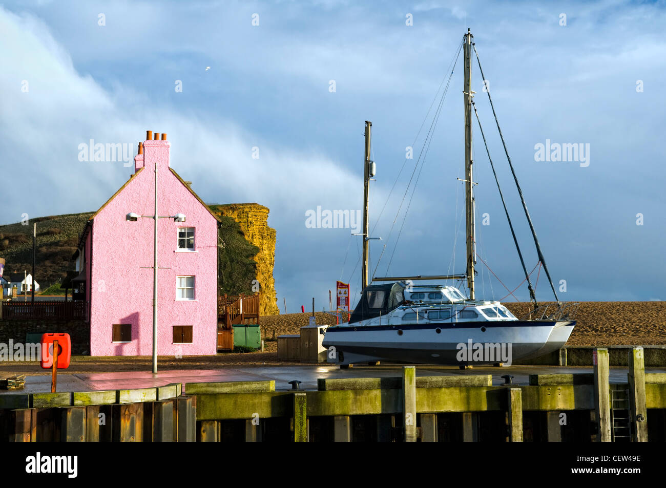 Scène colorée de house, de falaises et de voile pris de West Bay, port près de Bridport, Dorset, uk après une tempête en hiver Banque D'Images