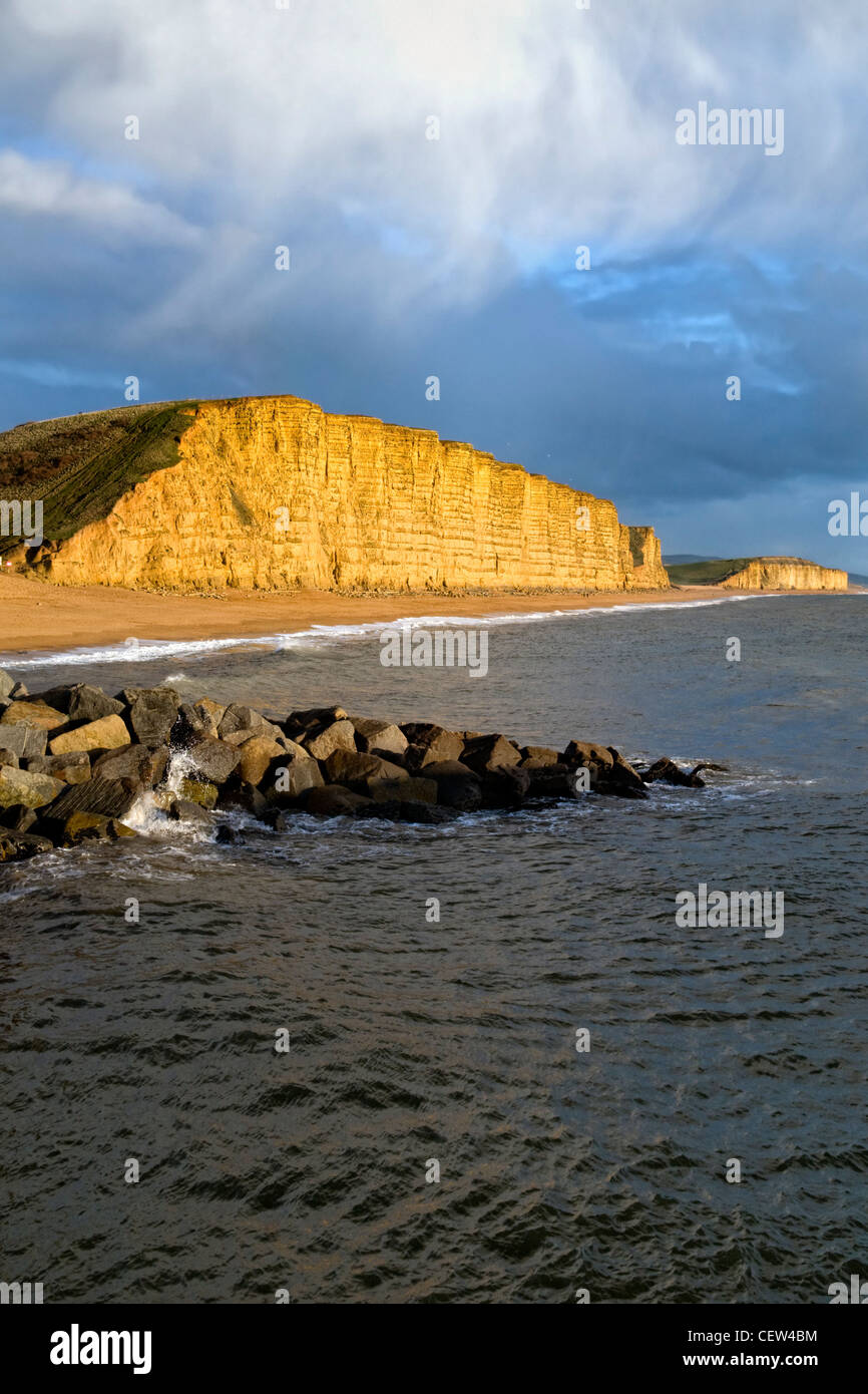 Falaises, plage et côte de West Bay, sur la côte jurassique dorset prises après une tempête en hiver et falaises éclairée par la lumière du soleil Banque D'Images