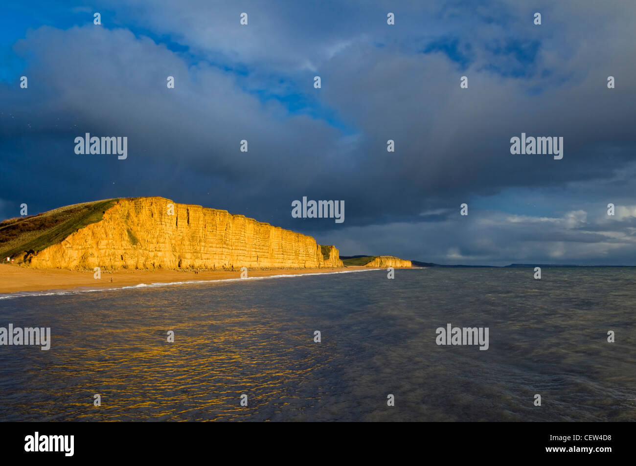Falaises, plage et côte de West Bay, sur la côte jurassique dorset prises après une tempête en hiver et falaises éclairée par la lumière du soleil Banque D'Images
