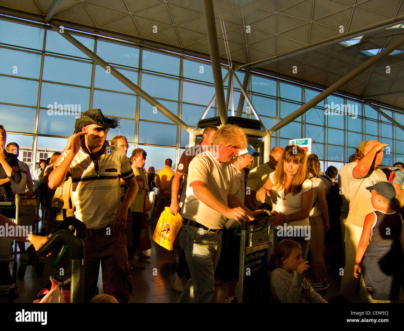 Les voyageurs attendent leurs bagages dans l'aéroport de Stansted, Essex Banque D'Images