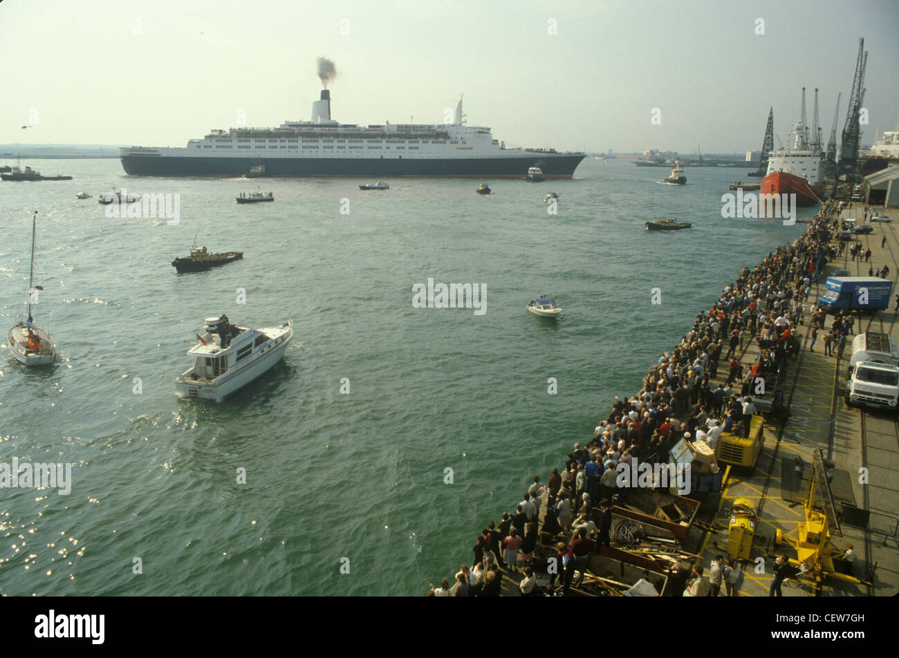 Le navire Queen Elizabeth 2 QE2 met les voiles pour les Malouines. La famille et les amis et une flottille de petits bateaux les envoient en route. MAI 1982 1980S ROYAUME-UNI HOMER SYKES Banque D'Images