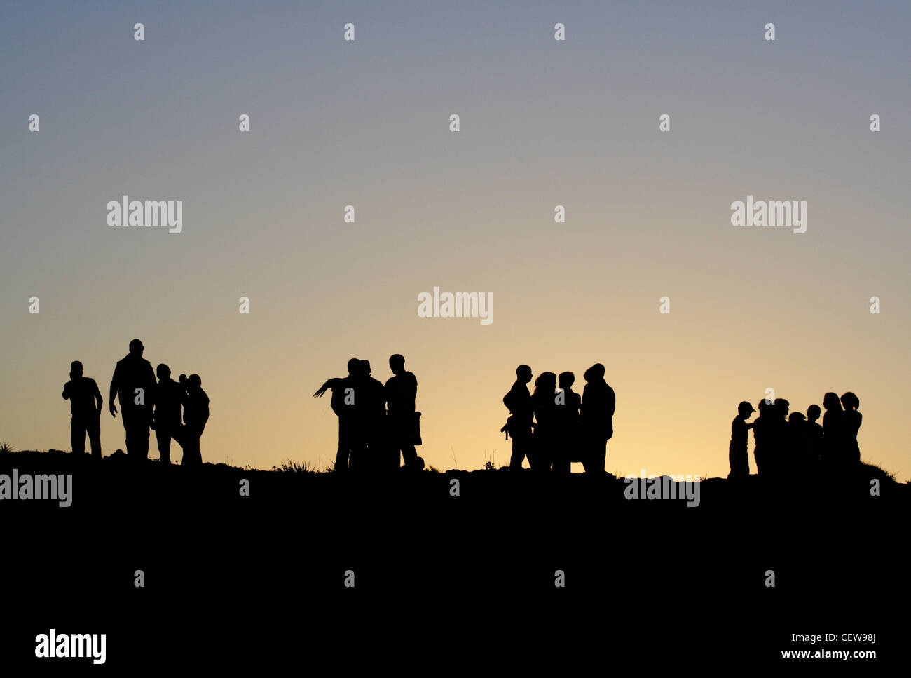 Des groupes de personnes en silhouette au crépuscule. Peut être utilisé en tant que concept de vie photo illustrant l'interaction sociale, la séparation entre les groupes etc. Banque D'Images