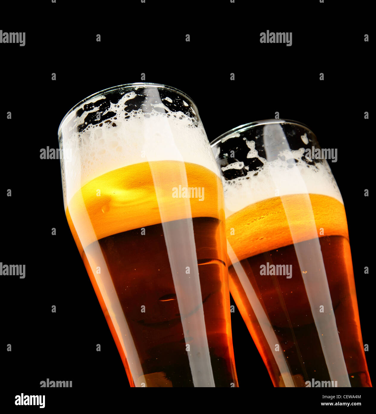 Deux verres de bière avec plus de mousse fond noir Banque D'Images