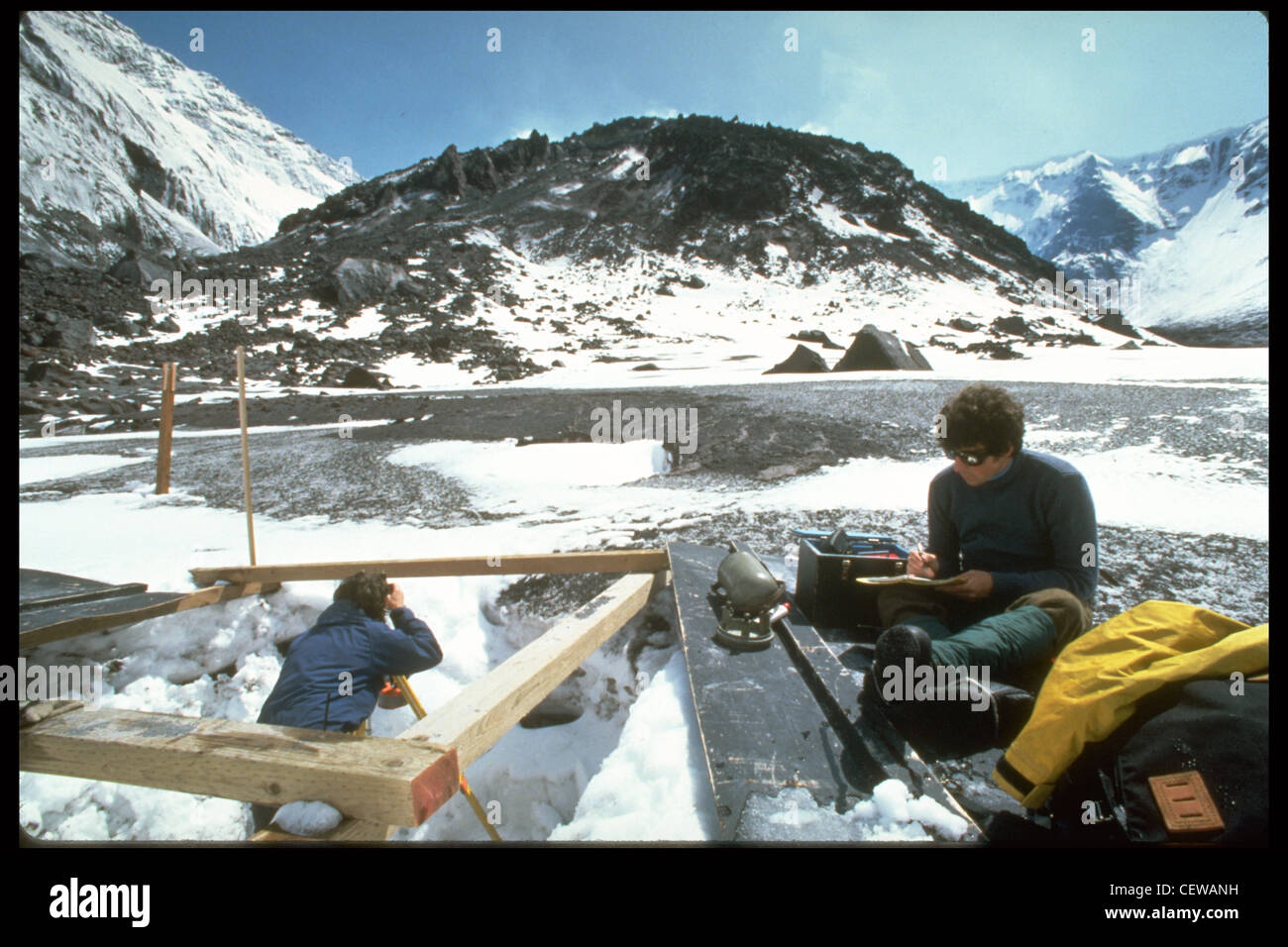 Les géologues de la U.S. Geological Survey utilisent une théodolite et un EDM (compteur de distance électronique) pour mesurer les angles et les distances de pente jusqu'au dôme de lave. Les changements de ces angles et de ces distances sont utilisés pour calculer les « taux de déformation ». Une augmentation des taux de déformation indique que le magma pénètre lentement dans le dôme. Au début des années 1980, les taux de déformation ont souvent atteint 30 pieds par heure (10 mètres/heure), le magma se levait et le dôme s'est agrandi avant le début de l'extrusion. Pendant les mois d'hiver, les postes d'instruments ont souvent dû être creusés hors de la neige avant de pouvoir effectuer des mesures. Banque D'Images