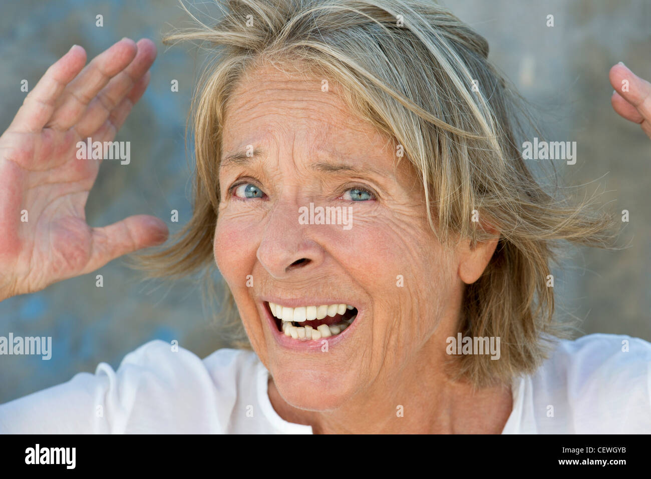 Senior woman with hands raised et l'apparence d'étonnement Banque D'Images