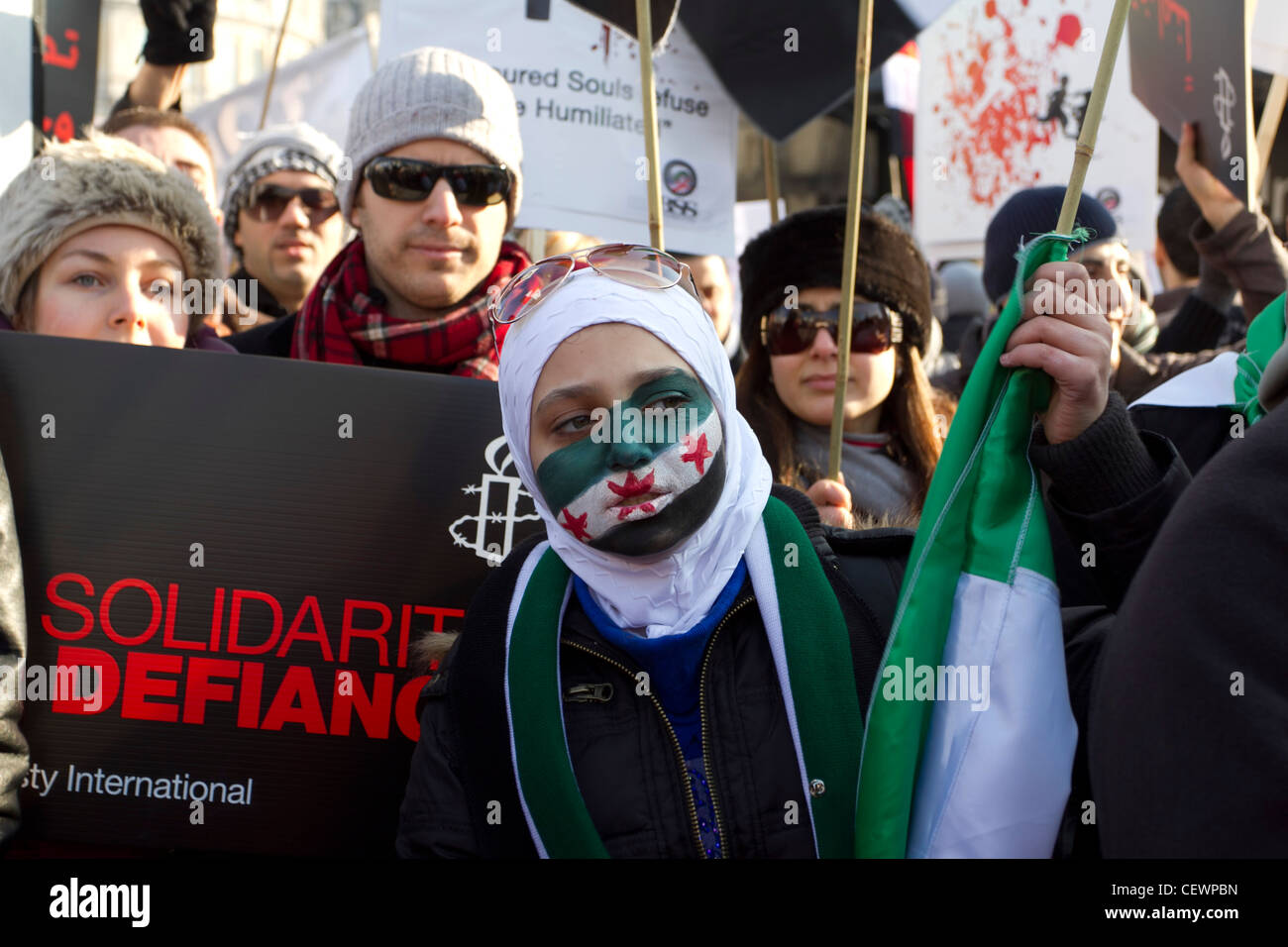 Manifestant une femme qu'on voit ici avec son visage peint avec le drapeau syrien Banque D'Images