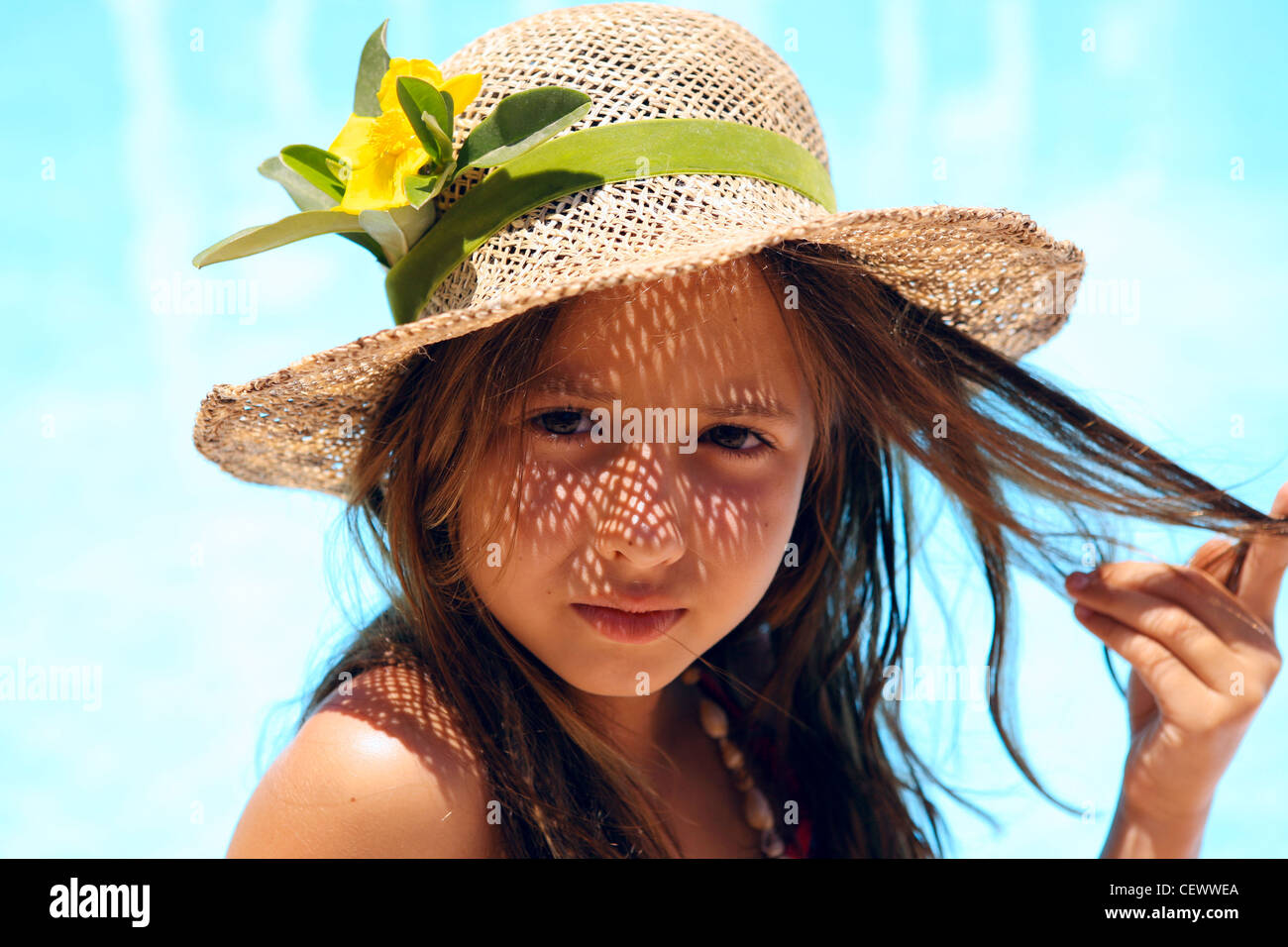 Petite fille portant un chapeau près de la piscine Banque D'Images