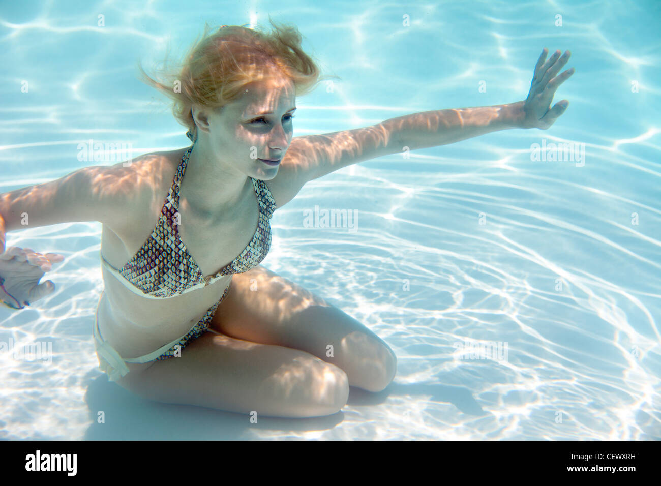 Girl swimming underwater in a swimming pool Banque D'Images