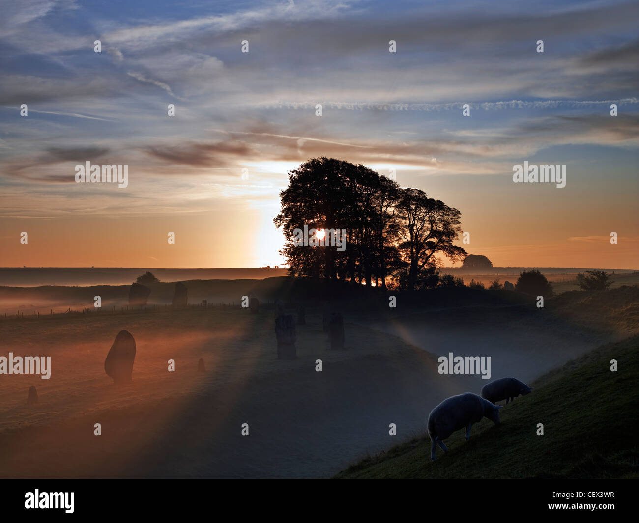 Lever de soleil sur l'Avebury Stone Circle, l'un des plus grands cercles de pierre préhistoriques, sur un jour d'automne brumeux. Banque D'Images