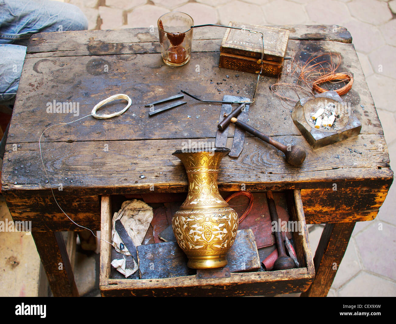 Les outils du commerce. Coppersmith traditionnel avec son banc de travail et des outils au Caire, Egypte Banque D'Images