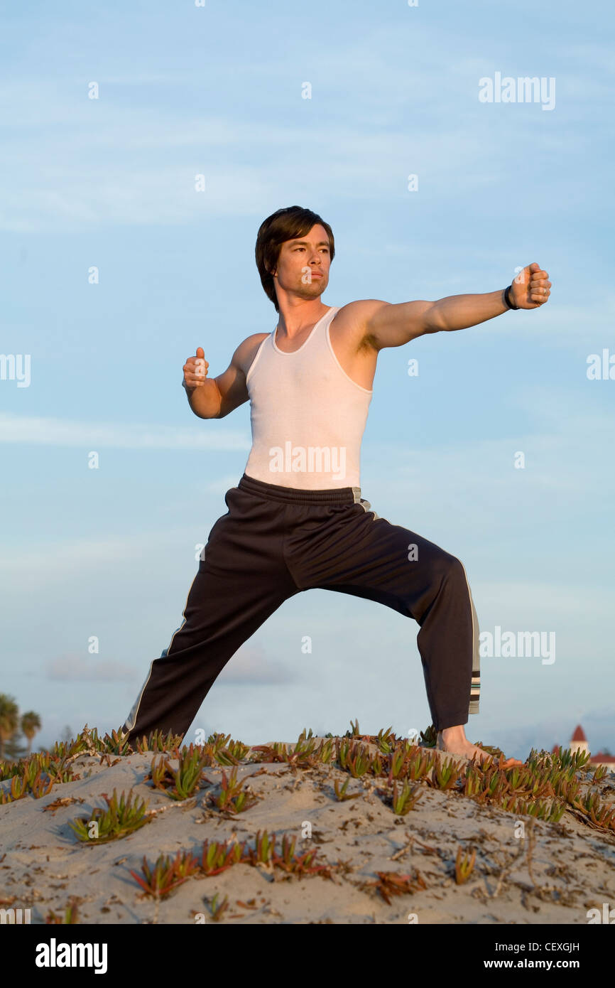 Man doing yoga on beach Banque D'Images
