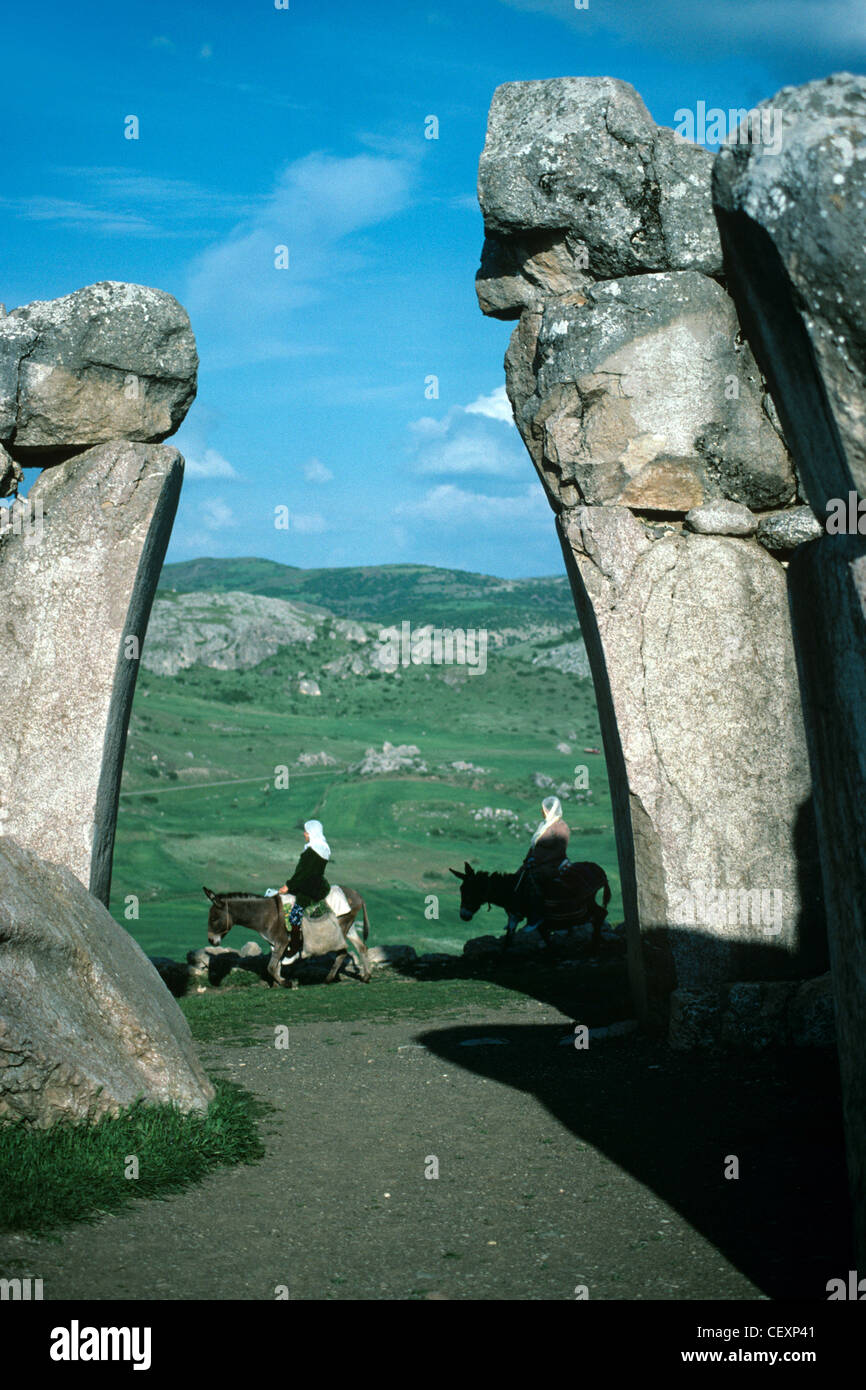 Les femmes paysannes Ride ânes passé le Lion Royal Gate à l'entrée de l'ancienne ville de Hittite Hattusha, Kharkov, Bogazkoy, Turquie Banque D'Images Les femmes paysannes Ride ânes passé le Lion Royal Gate à l'entrée de l'ancienne ville de Hittite Hattusha, Kharkov, Bogazkoy, Turquie Banque D'Images