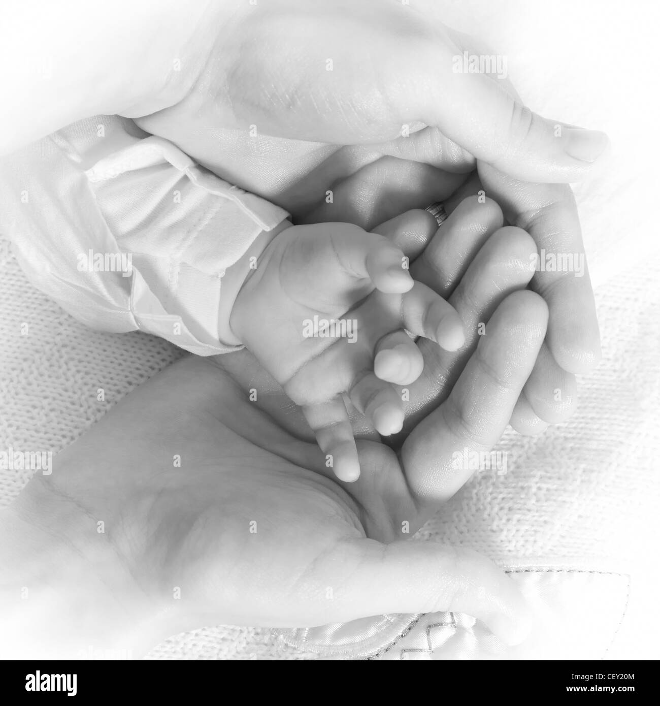 Bébé nouveau-né main tenir avec soin par les mains de la mère. Image en  noir et blanc Photo Stock - Alamy