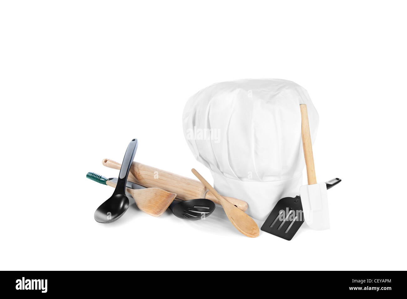 Chef's Hat avec divers ustensiles de cuisine y compris un rouleau, spatule en bois et en plastique et de cuillères. Banque D'Images