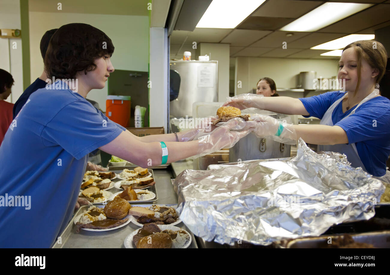 Les bénévoles de l'école secondaire servent le repas à l'abri de la mission de sauvetage Banque D'Images