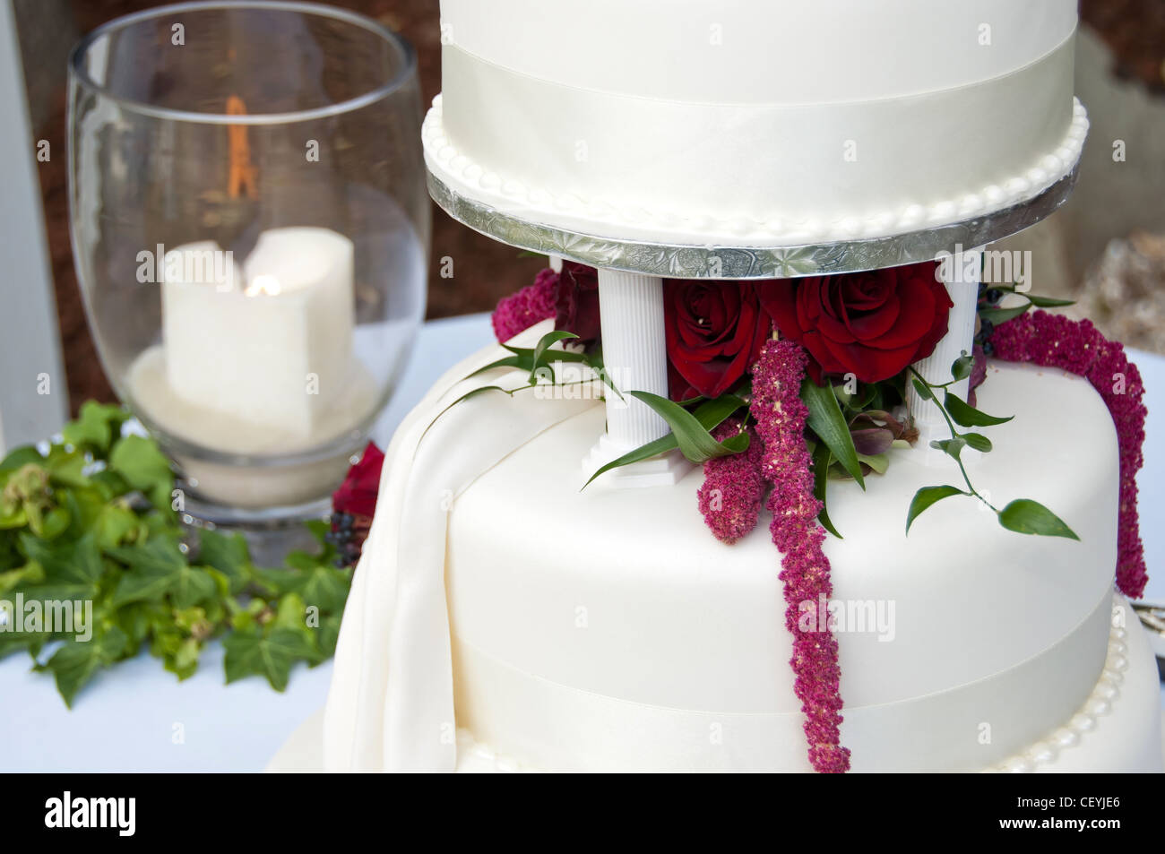 Gâteau de mariage et souvenir bougie sur une table lors d'un mariage avec des fleurs Banque D'Images