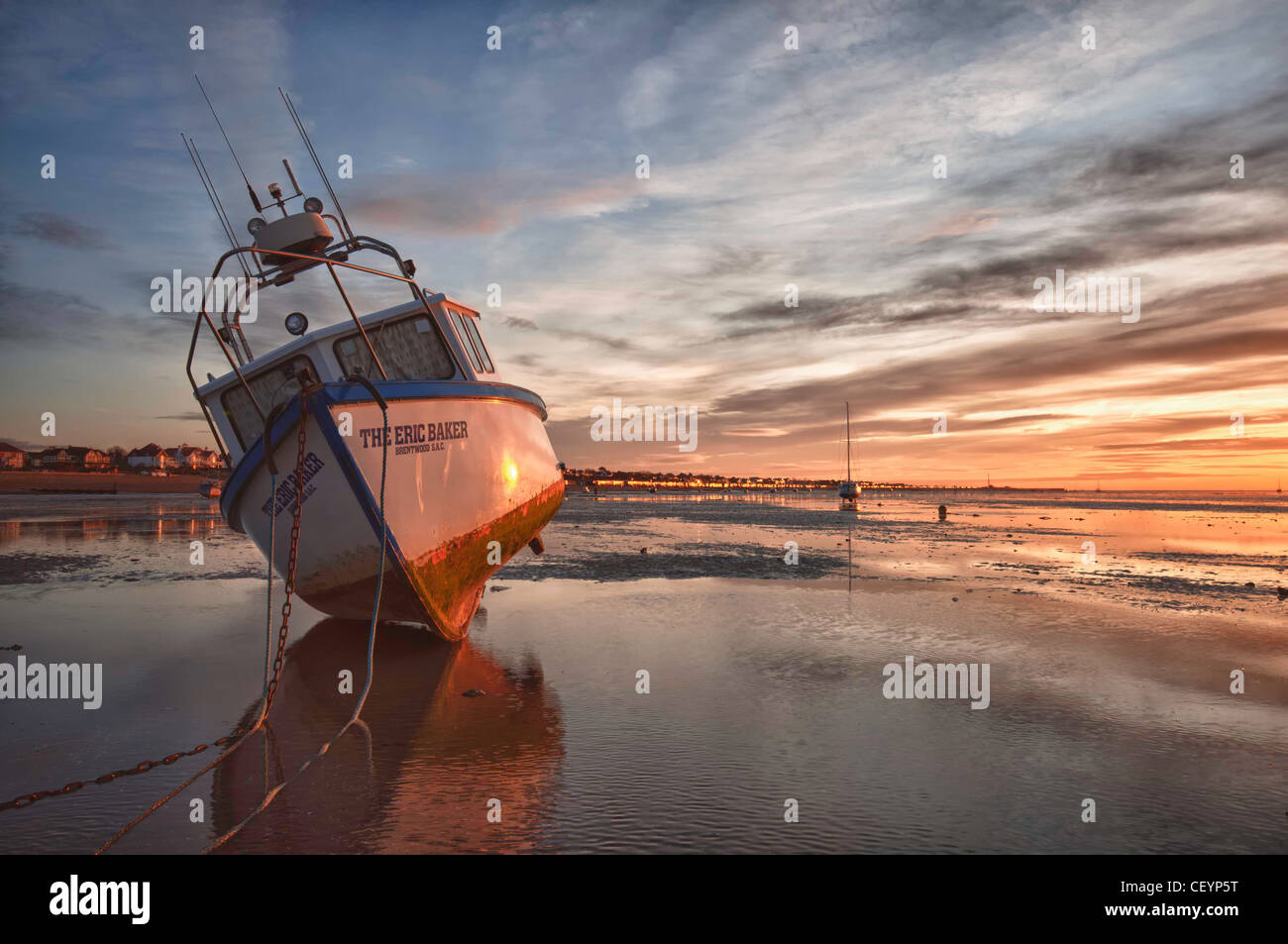 Un bateau amarré au lever du soleil pendant la marée basse à 'Thorpe Bay' Essex Banque D'Images