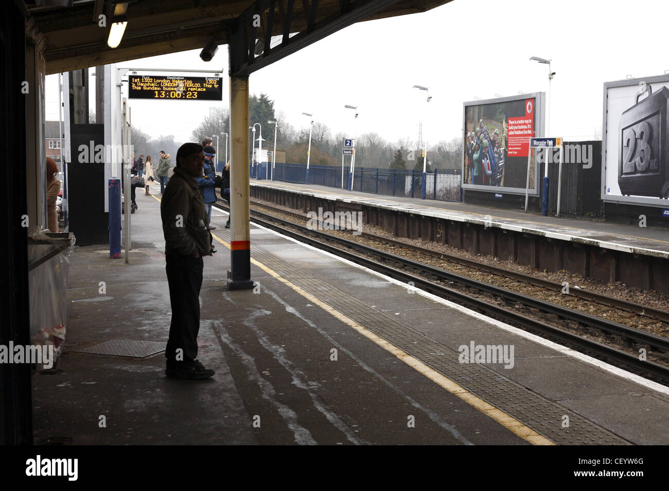 Les passagers en attente d'un train sur un quai de la gare. Banque D'Images