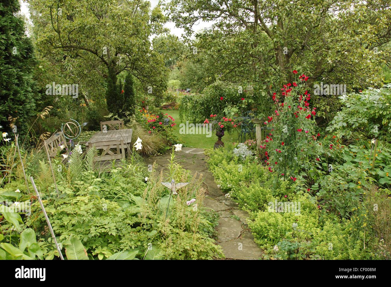 Tous les détails de l'image Seasons Garden garden chemin menant à un jardin avec mobilier de jardin sur la gauche Banque D'Images