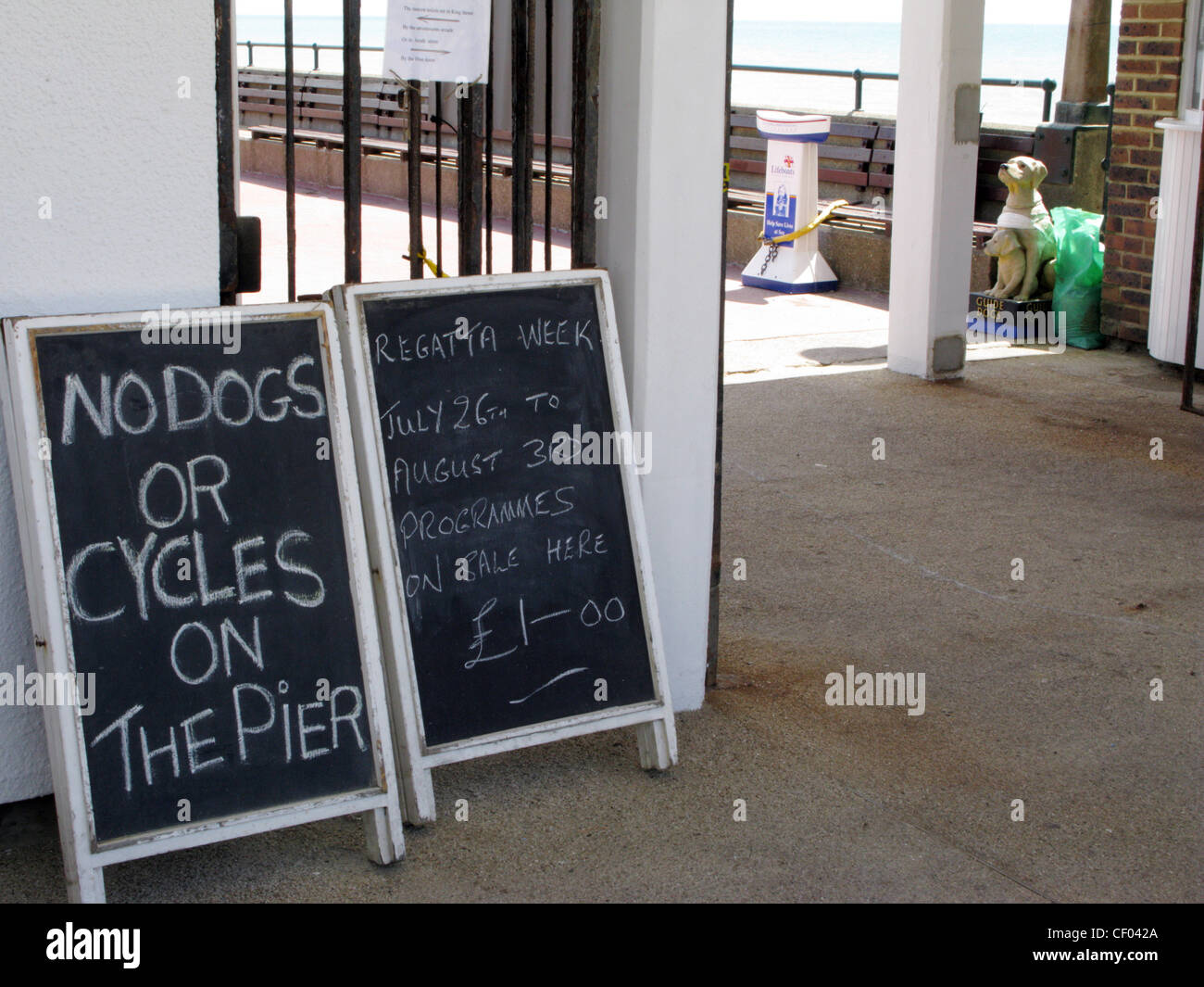 Panneau disant Pas de chien ou de cycles sur la jetée de Deal, Kent. Chiens guides d'aveugles la collecte fort en forme d'un chien Banque D'Images