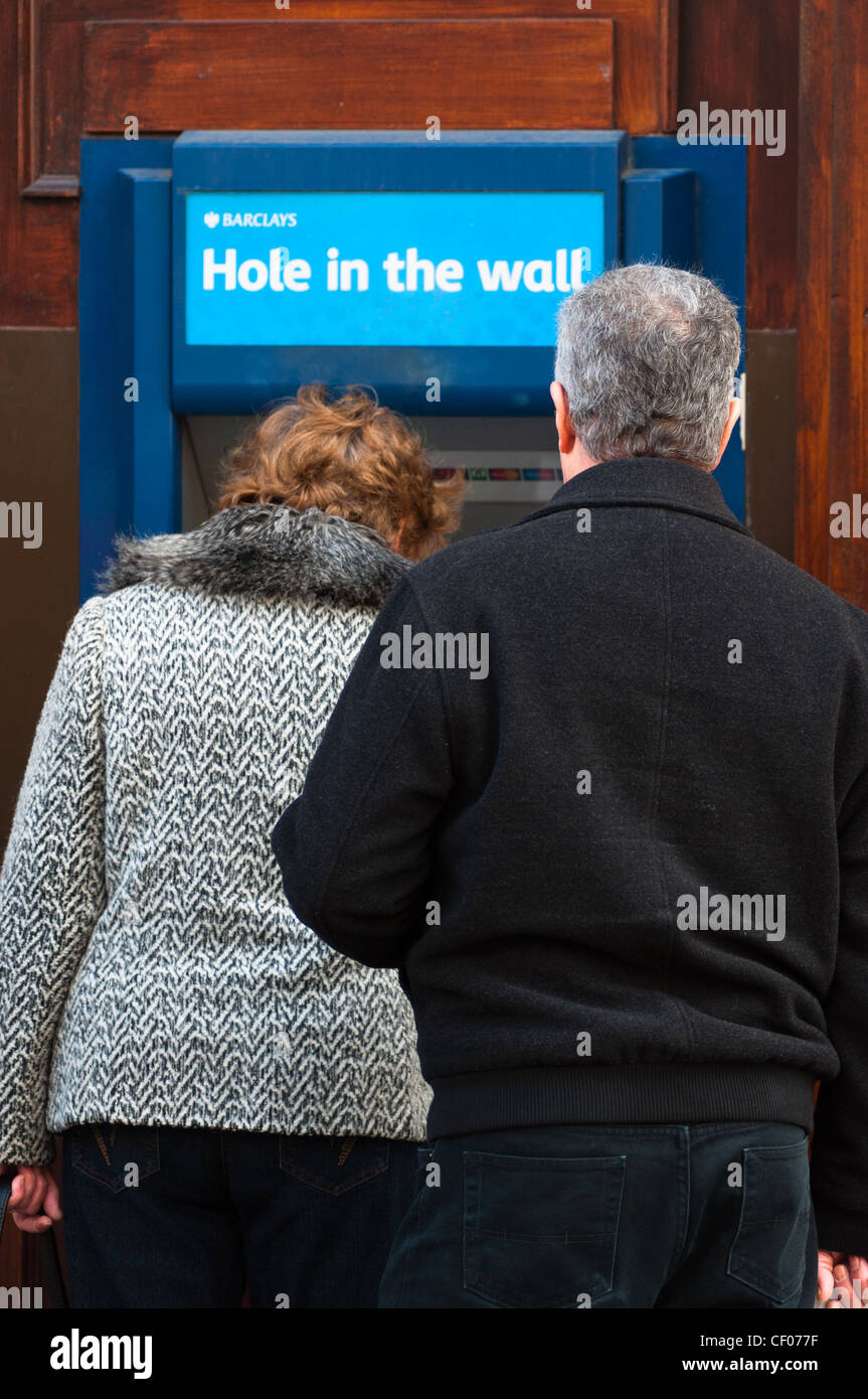 Les gens à l'aide d'espèces locales Barclays 'Hole in the Wall' cash machine, England, UK. Banque D'Images