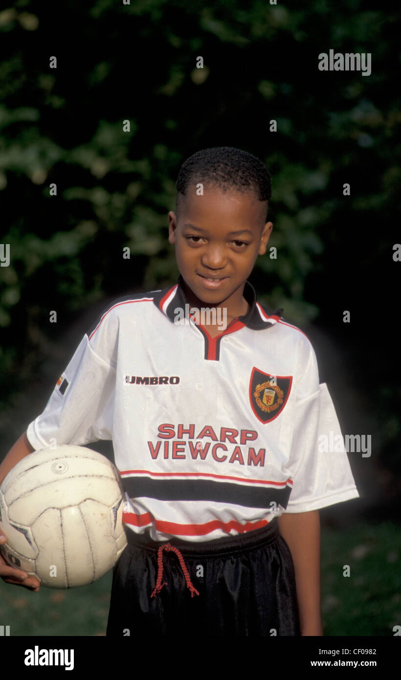 Jeune garçon noir dans le football gear Banque D'Images