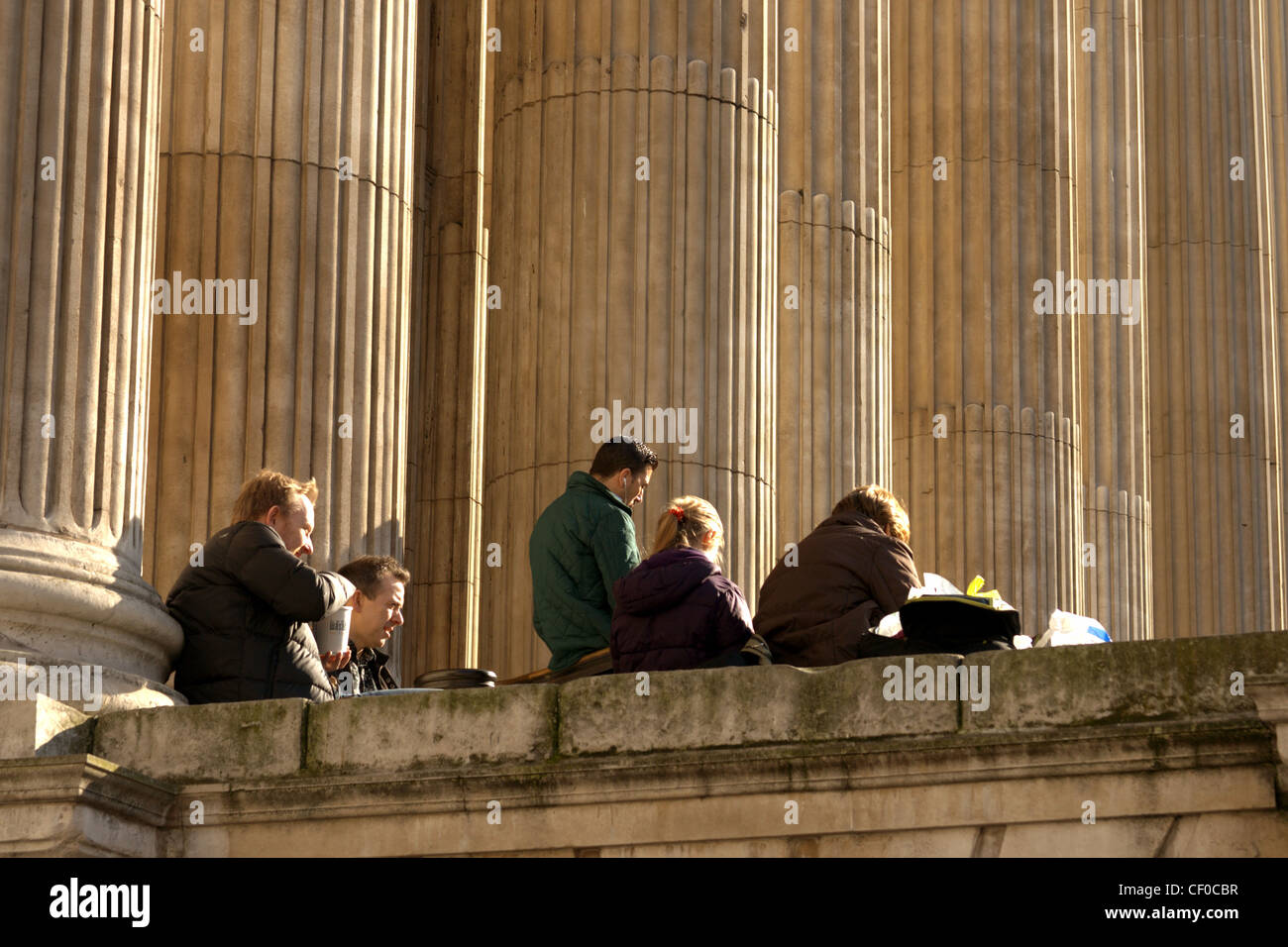 Les visiteurs assis sur les marches de la Cathédrale St Paul de prendre le soleil de l'après-midi. Banque D'Images