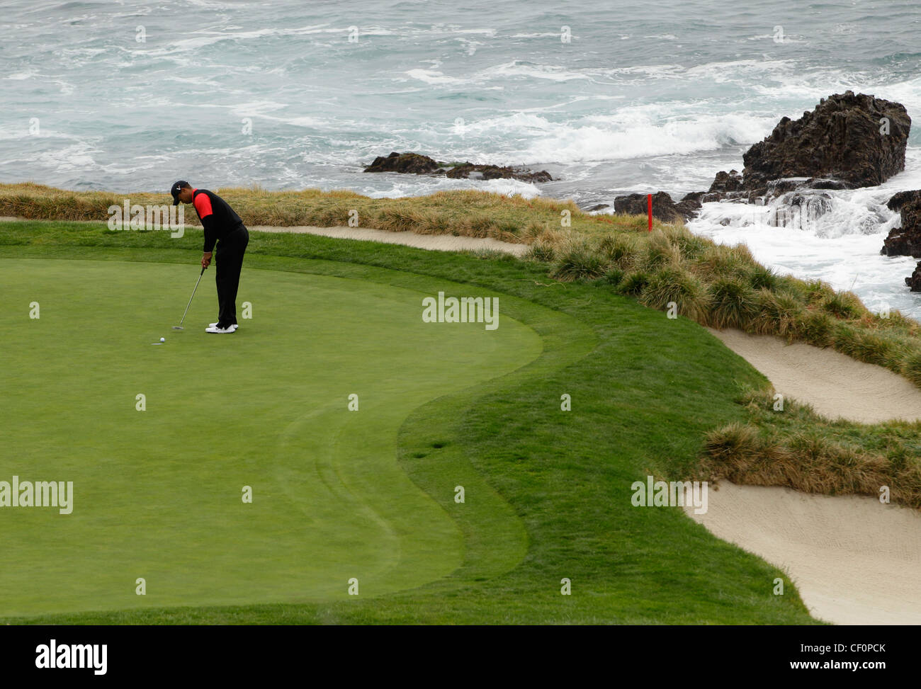Tiger Woods joue un trou d'eau, à Pebble Beach Banque D'Images