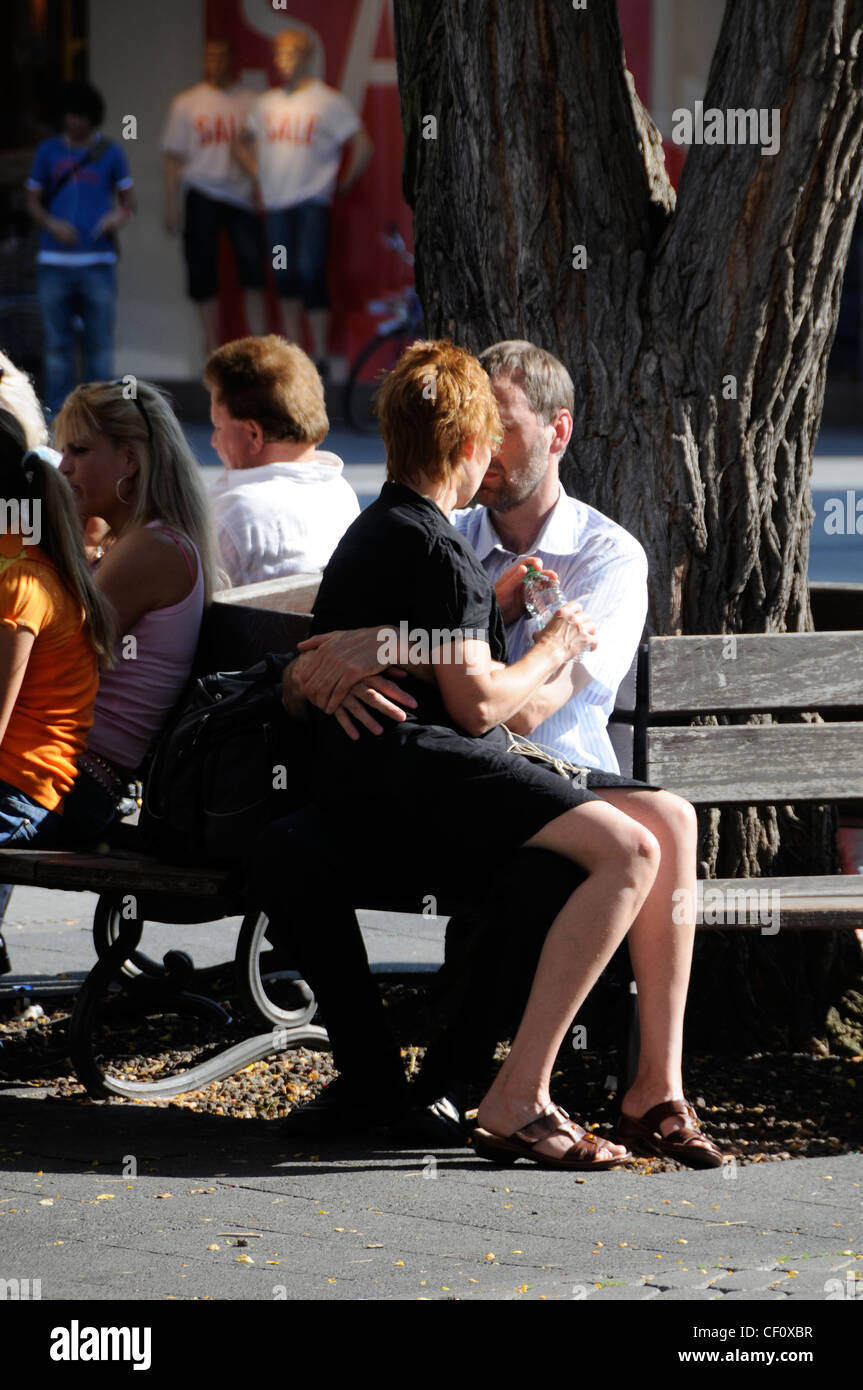 Un jeune couple trouve le temps d'une petite passion au soleil dans une rue commerçante animée de Nuremberg, en Allemagne Banque D'Images