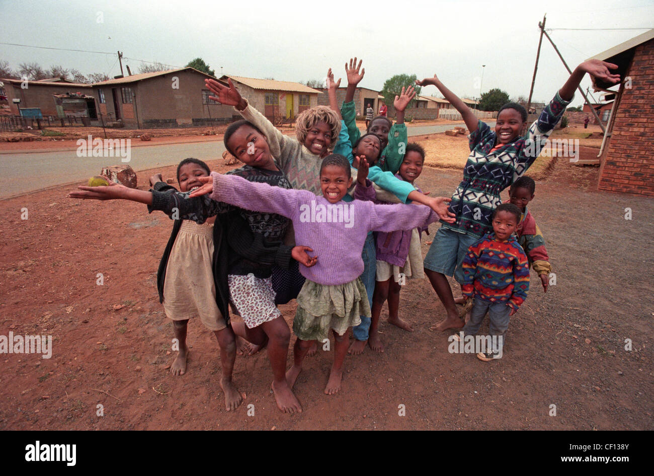 Le Canton de Barefoot kids, l'un portant une perruque de Marilyn Monroe, donner une chaleureuse bienvenue à Soweto, Afrique du Sud en 1996 Banque D'Images