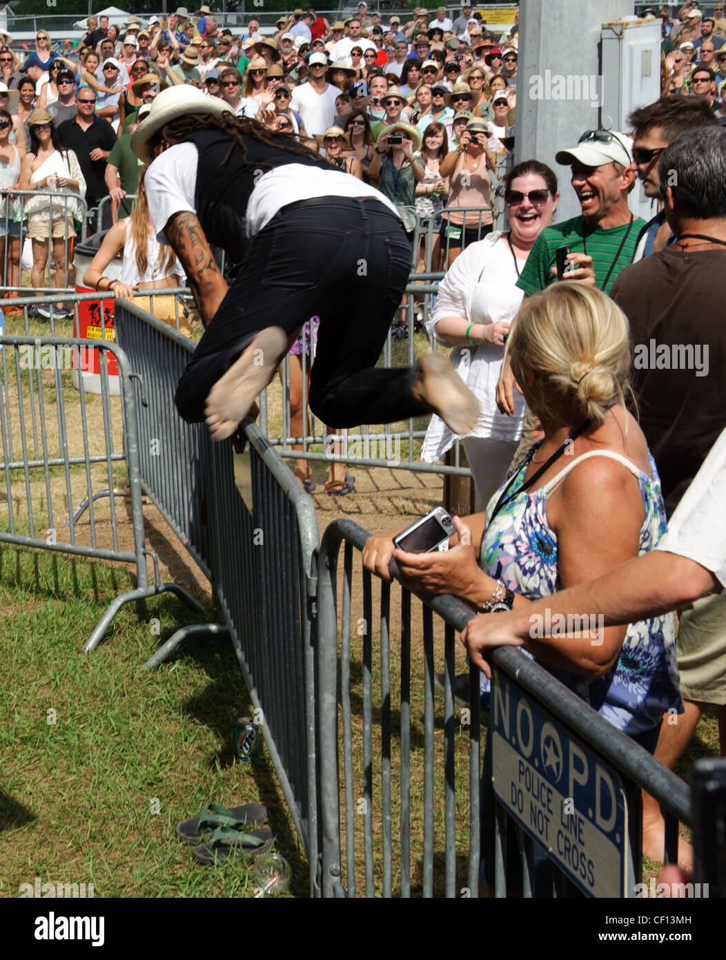 Michael Franti sautant par-dessus une barrière lors de sa performance au Festival de jazz et du patrimoine à New Orleans, LA. Banque D'Images