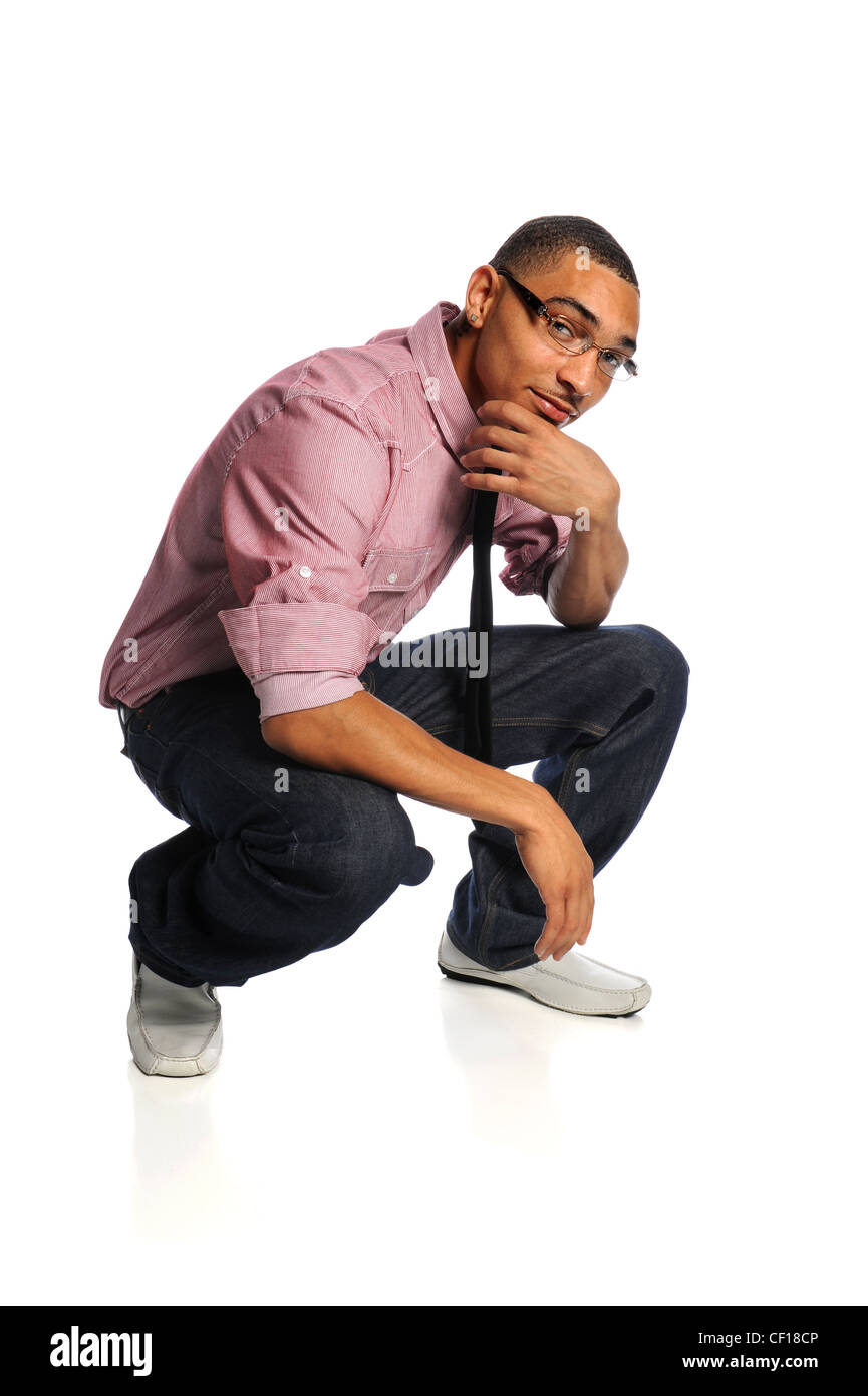 Portrait of young African American man crouching with hand on chin isolé sur fond blanc Banque D'Images