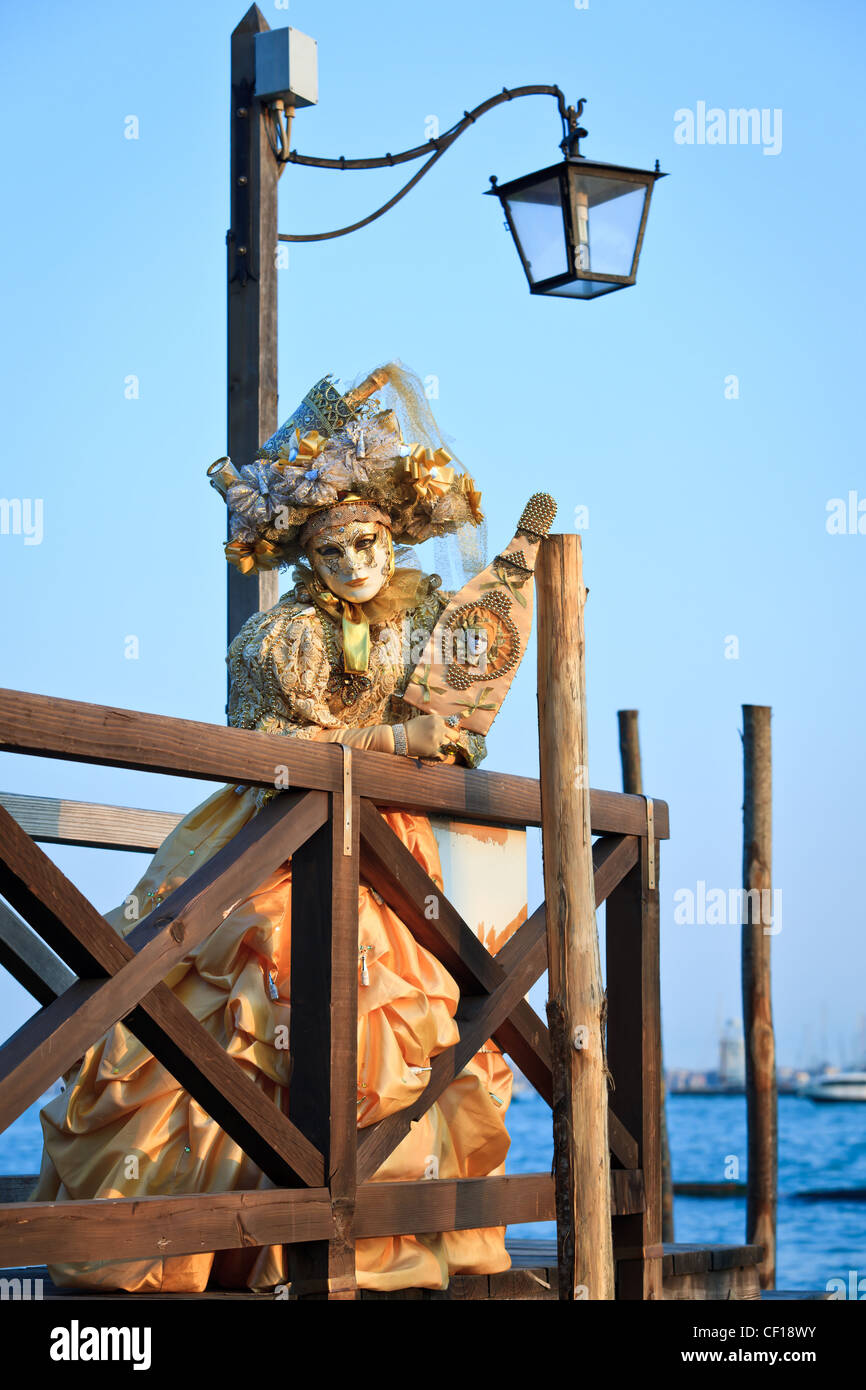 Masked woman standing on a pier pendant le Carnaval de Venise, Vénétie, Italie Banque D'Images