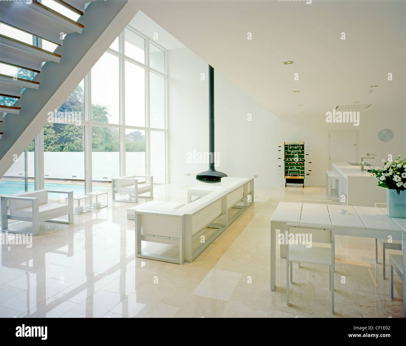 Le interiof un carré blanc maison moderniste, mobilier blanc et un salon ouvert, salle à manger et coin cuisine Glenn Dearing Banque D'Images