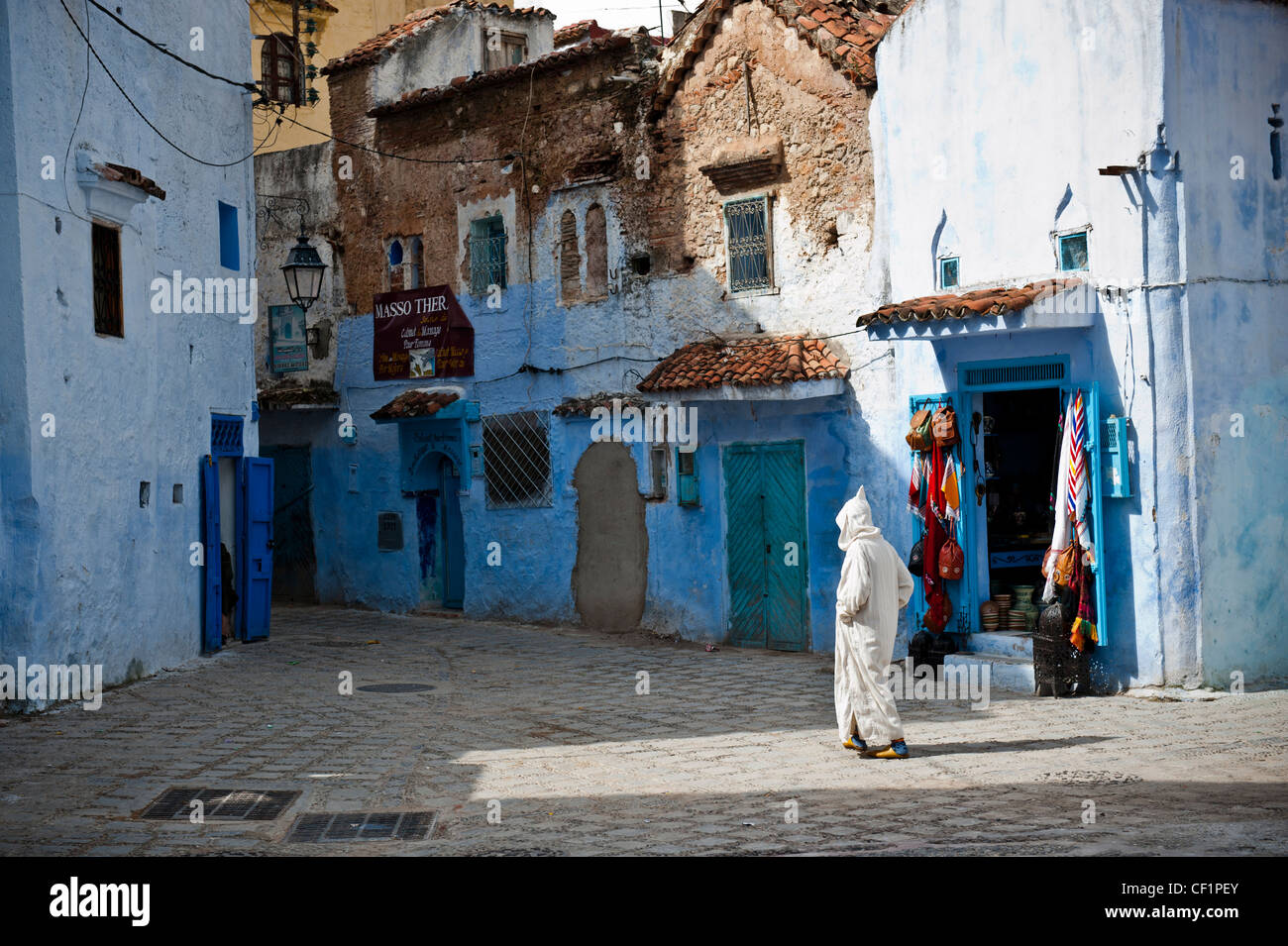 Muslim man walking in the blue remparts de la vieille médina de Chefchaouen, Maroc Banque D'Images