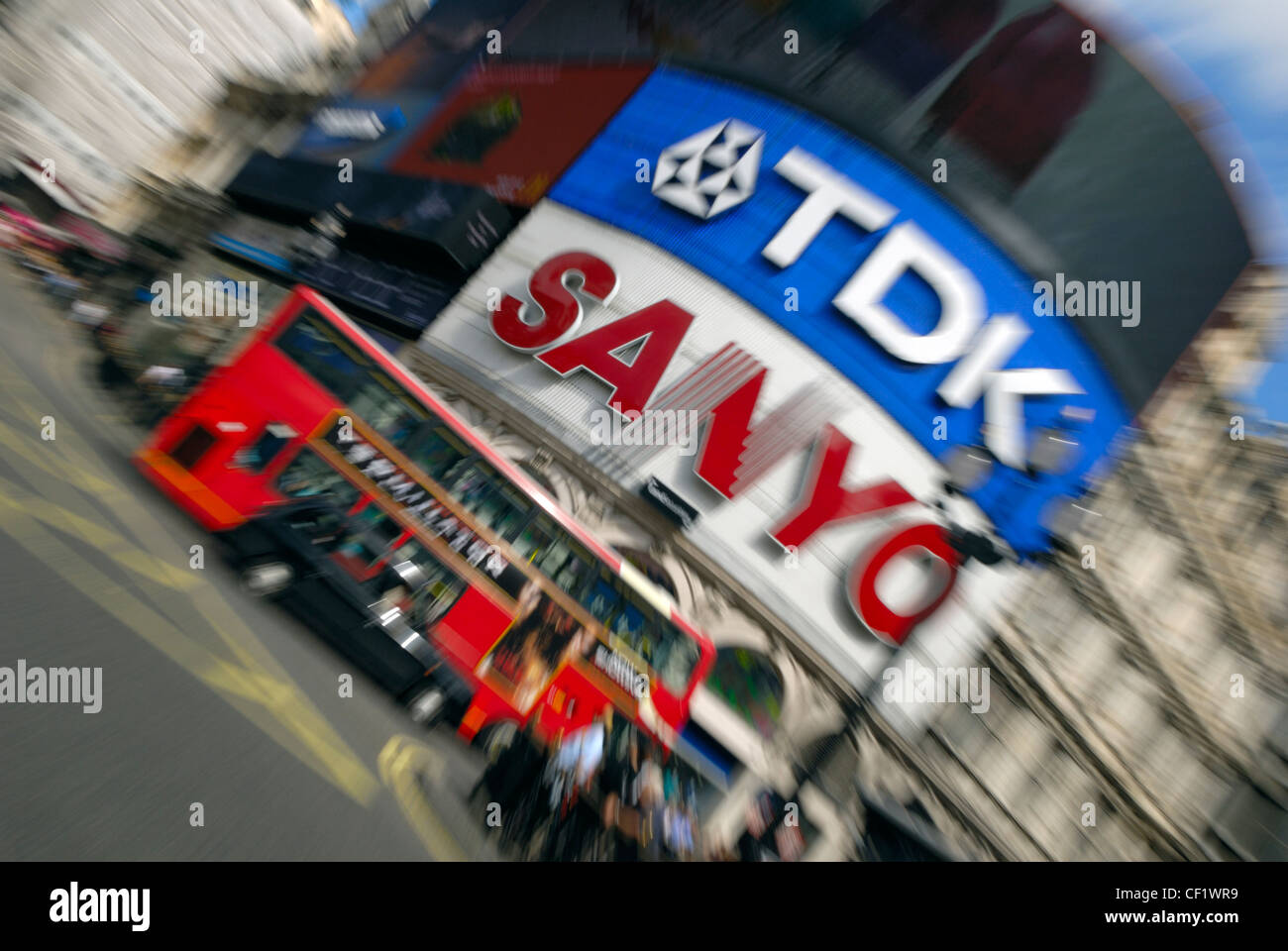 Un taxi et London bus passant l'emblématique annonces dans Piccadilly Circus. Banque D'Images