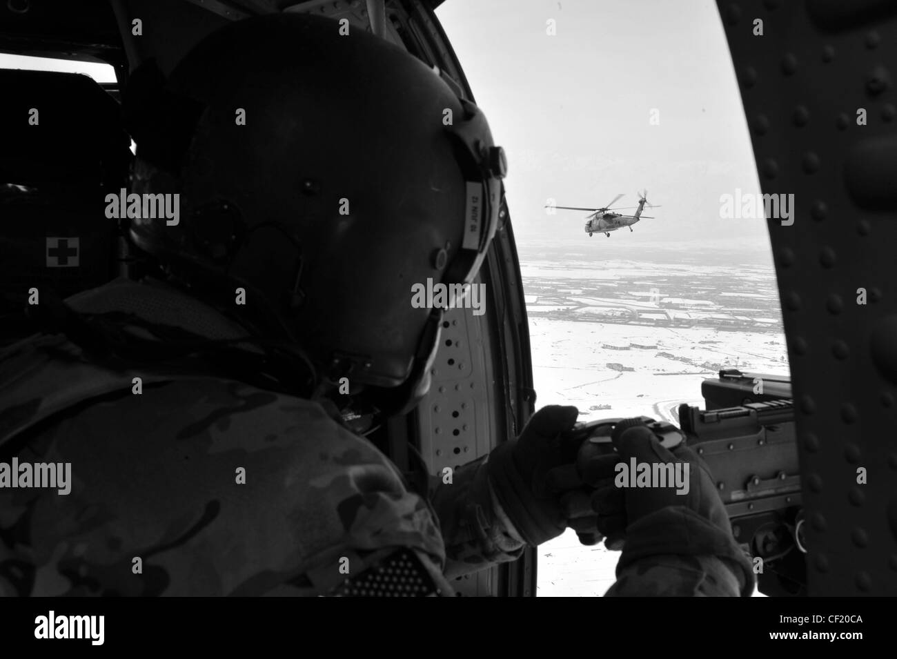 Sergent de l'armée américaine Jesse Hooker, chef d'équipage UH-60 Black Hawk de Shreveport, en Louisiane, affecté à UN talon de la Force opérationnelle aérienne 3-82 au terrain d'aviation de l'armée de Bagram, balaye le terrain lors d'un vol au-dessus de Kaboul, en Afghanistan, le 25 février 2012. L'unité effectue des missions de circulation sur le champ de bataille pour la Force opérationnelle interarmées 1, la Force opérationnelle Poséidon et la Force opérationnelle talon. Le Faucon noir UH-60 est utilisé depuis la fin des années 1970 et demeure l'un des hélicoptères de transport tactique utilitaires les plus polyvalents et les plus fiables du militaire. Banque D'Images