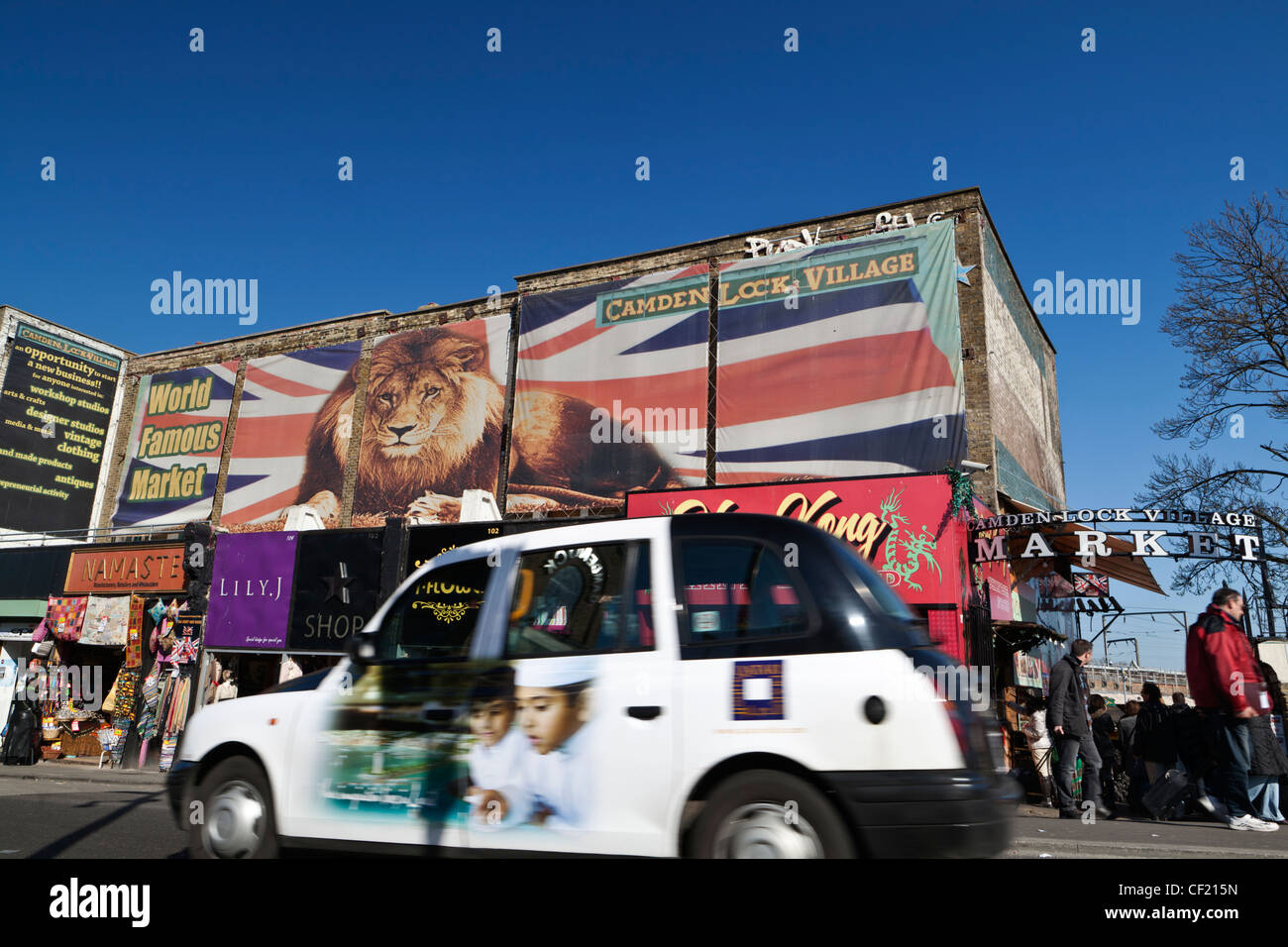 Un taxi de Londres en passant une entrée de Camden Lock Village Market. Banque D'Images