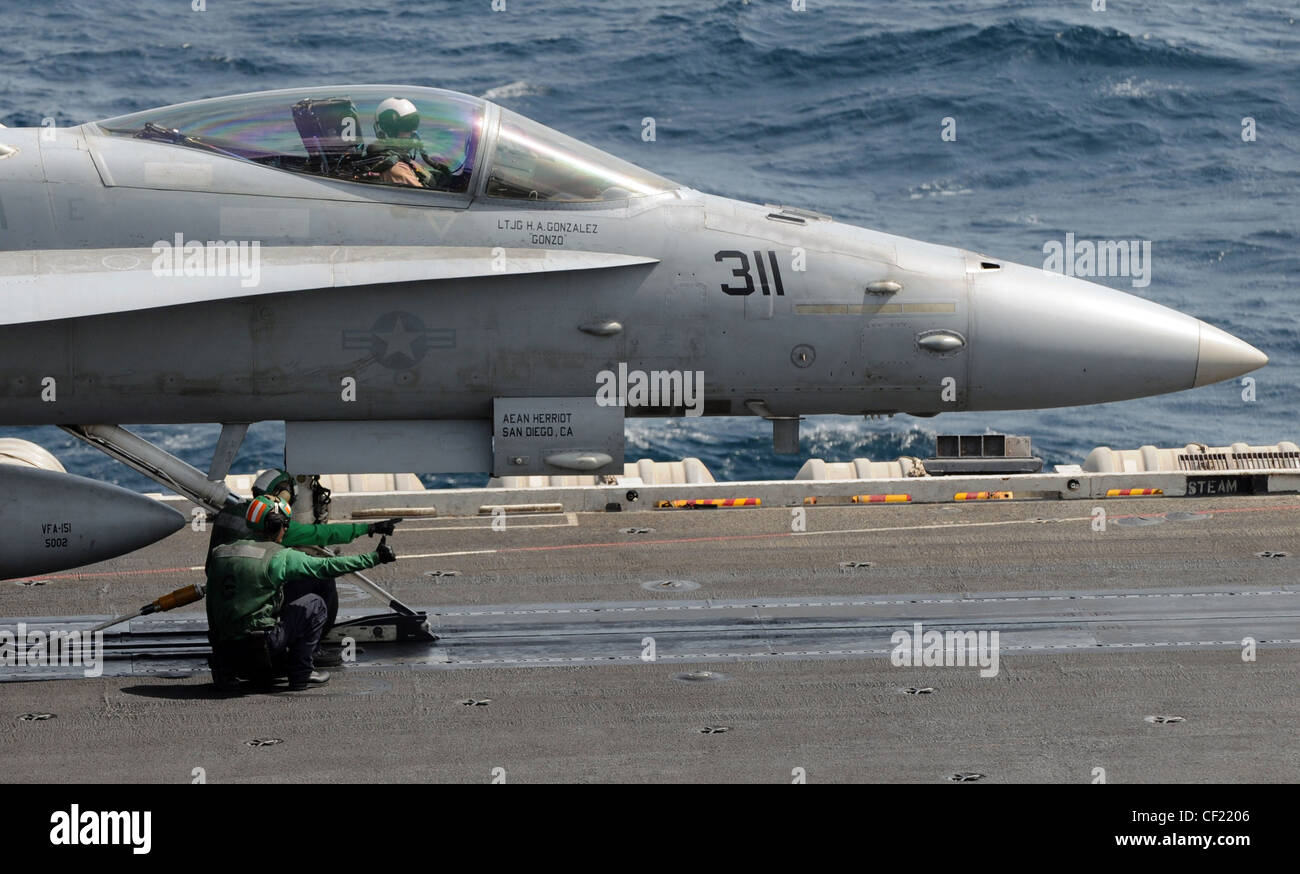 MER D'ARABIE (fév 26, 2012) les compagnons de bateaux d'aviation guident la barre de remorquage d'un Hornet F/A-18C affecté aux vigilantes de l'escadron de chasseurs de grève (VFA) 151 dans une navette catapulte sur le pont de vol du porte-avions de la classe Nimitz USS Abraham Lincoln (CVN 72). Abraham Lincoln est déployé dans la zone de responsabilité de la 5e flotte américaine, en effectuant des opérations de sécurité maritime, des efforts de coopération en matière de sécurité dans les théâtres et des missions de soutien dans le cadre de l'opération Enduring Freedom. Banque D'Images