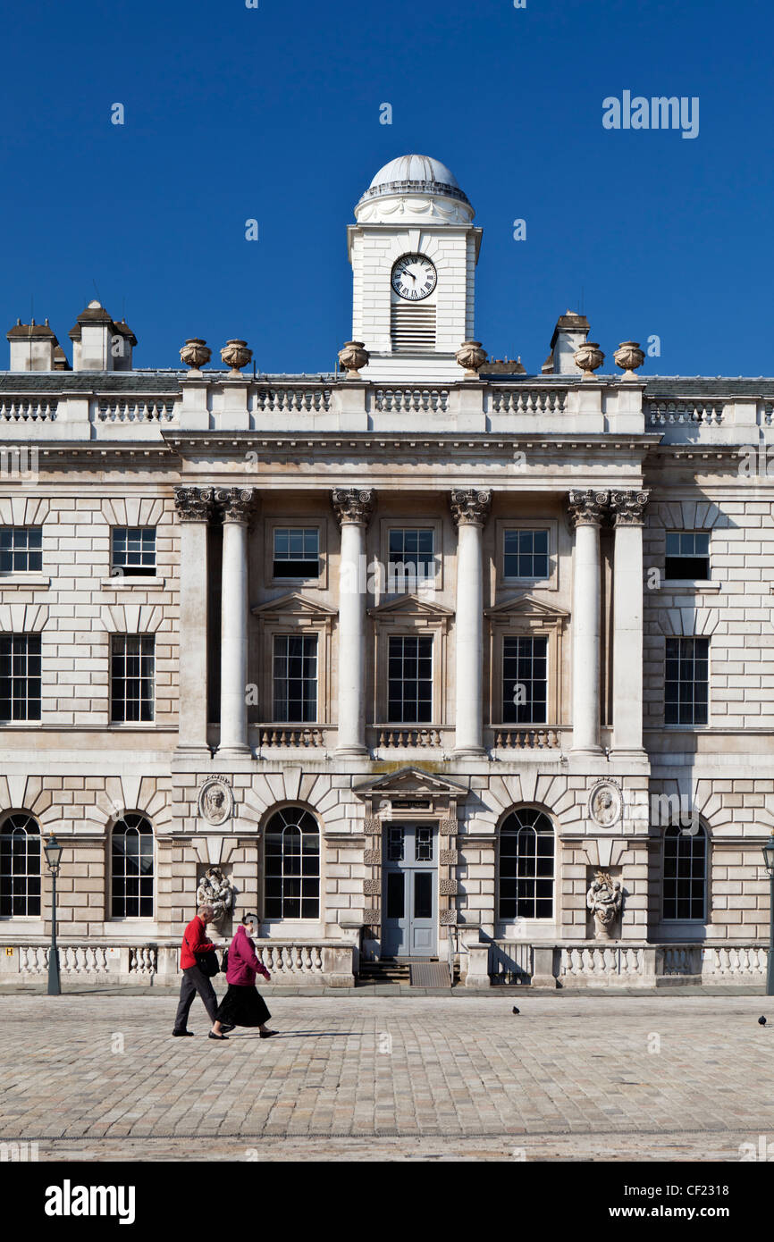 Un couple en train de marcher dans la cour après le HM Revenue & Customs Building à Somerset House. Banque D'Images