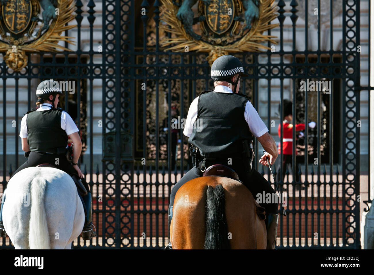 Les agents de la police montée et un imprimeur de la garde à l'extérieur de Buckingham Palace. Banque D'Images