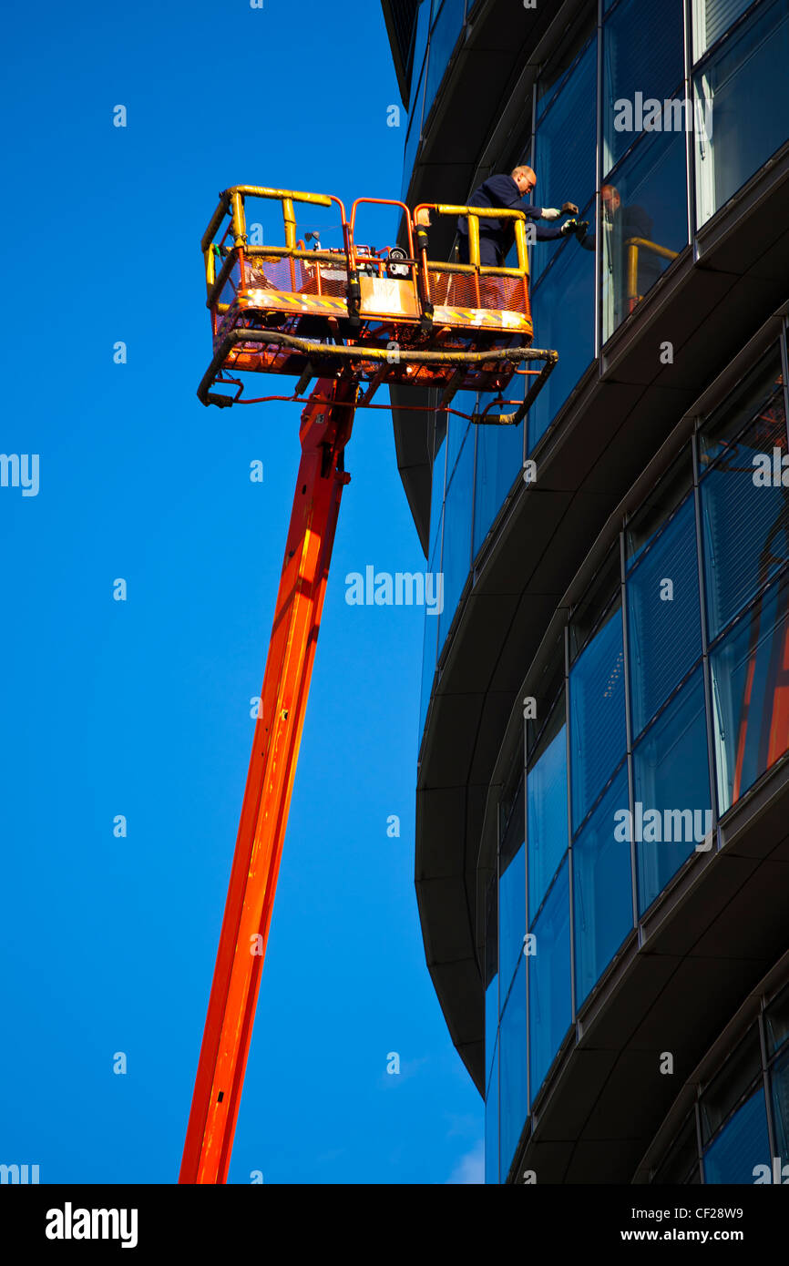 Un ouvrier d'entretien d'une grue sur une fenêtre de l'hôtel de ville, accueil de la Greater London Authority (GLA) compr Banque D'Images