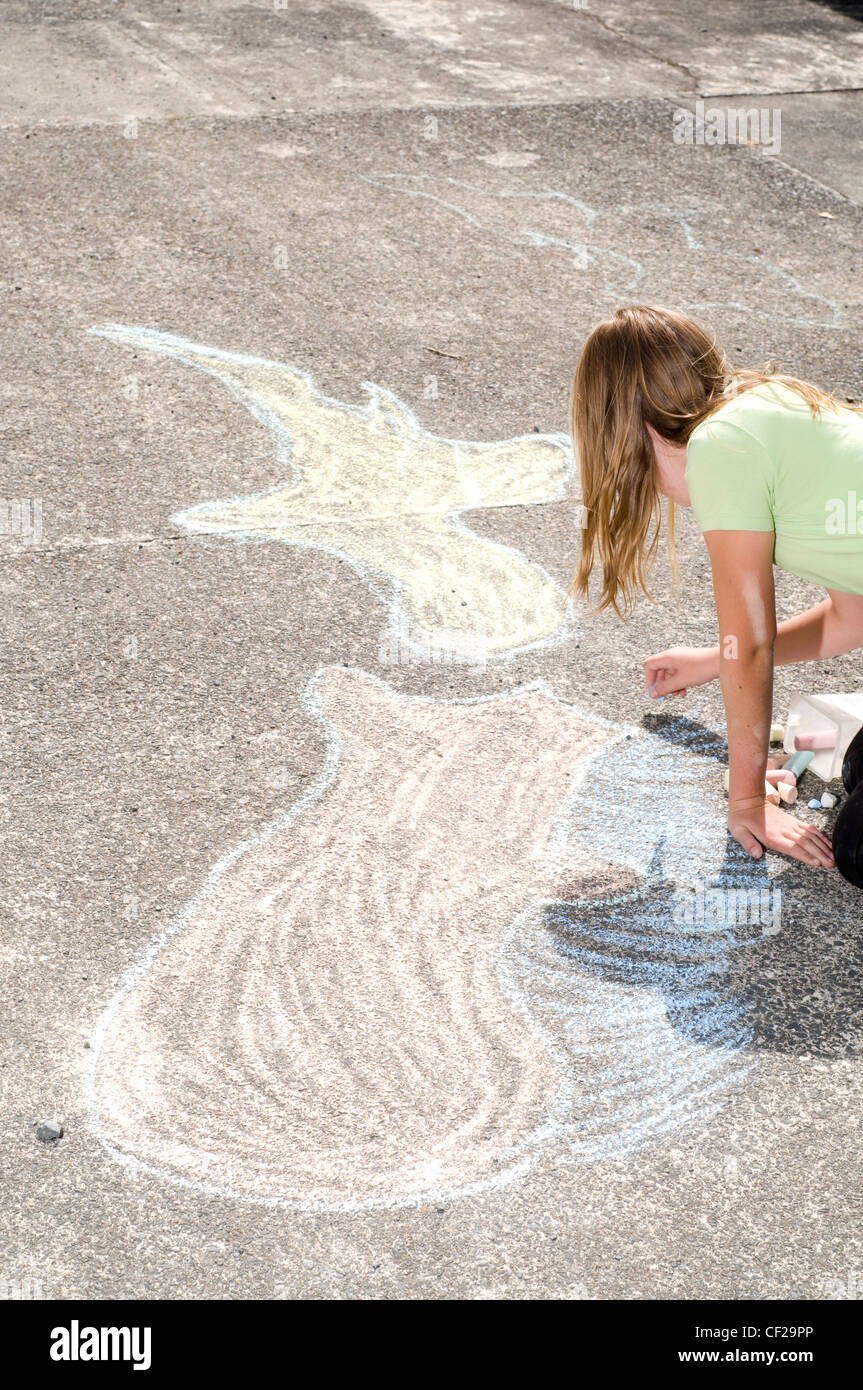Jeune fille dessiner avec les craies sur pavment Banque D'Images