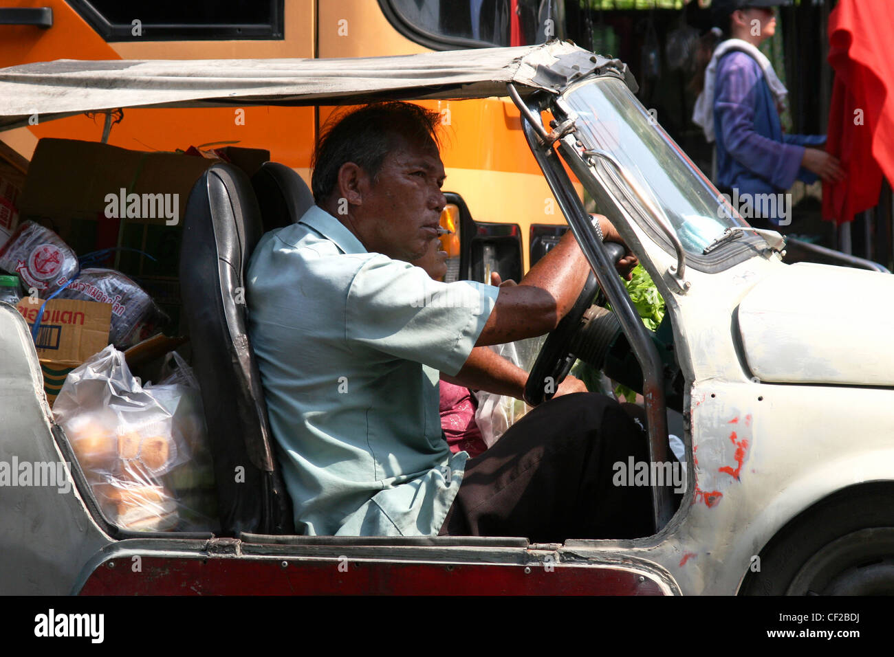 Un homme est au volant d'une vieille bagnole pleine charge (voiture) sur une rue de ville de Bangkok, Thaïlande. Banque D'Images Un homme est au volant d'une vieille bagnole pleine charge (voiture) sur une rue de ville de Bangkok, Thaïlande. Banque D'Images