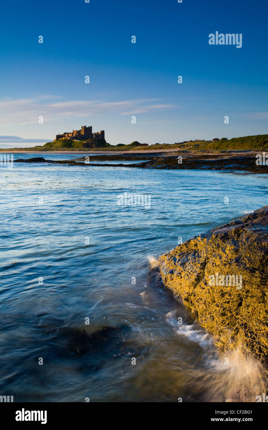 Château de Bamburgh, la plage et les dunes vue peu après le lever du soleil à partir de Harkess Rocks. Banque D'Images